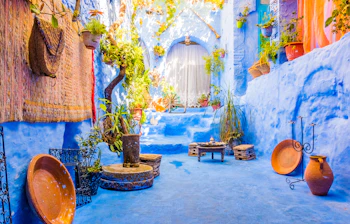 Autentisk marokkansk stemning i Chefchaouen med blåmalede vægge, traditionelle lerpotter og hængende planter