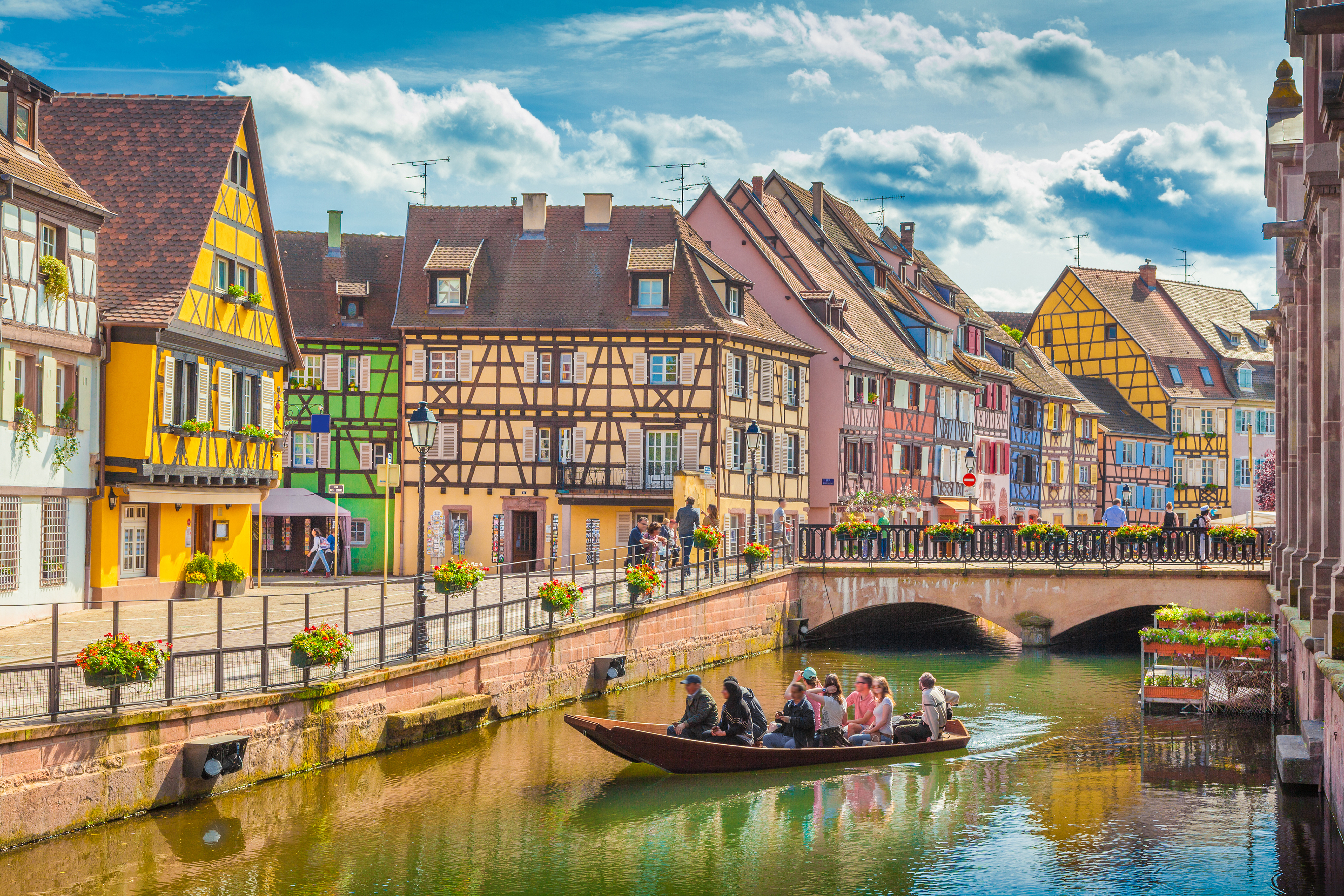 Traditionelle bindingsværkshuse langs kanal i Colmar Alsace med turistbåd