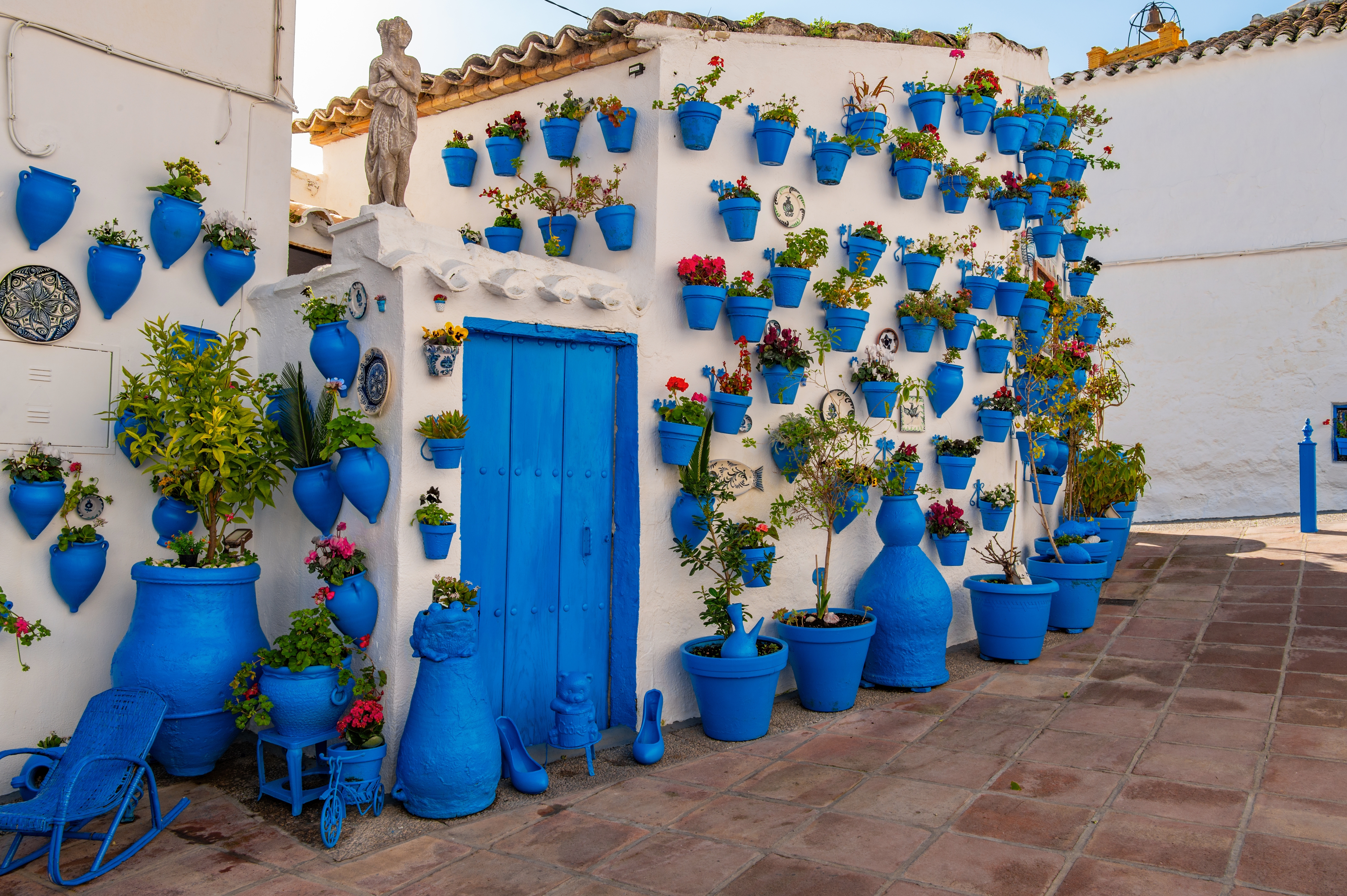 Smukke gårdsplads i Cordoba med blå blomsterkrukker og traditionel spansk arkitektur