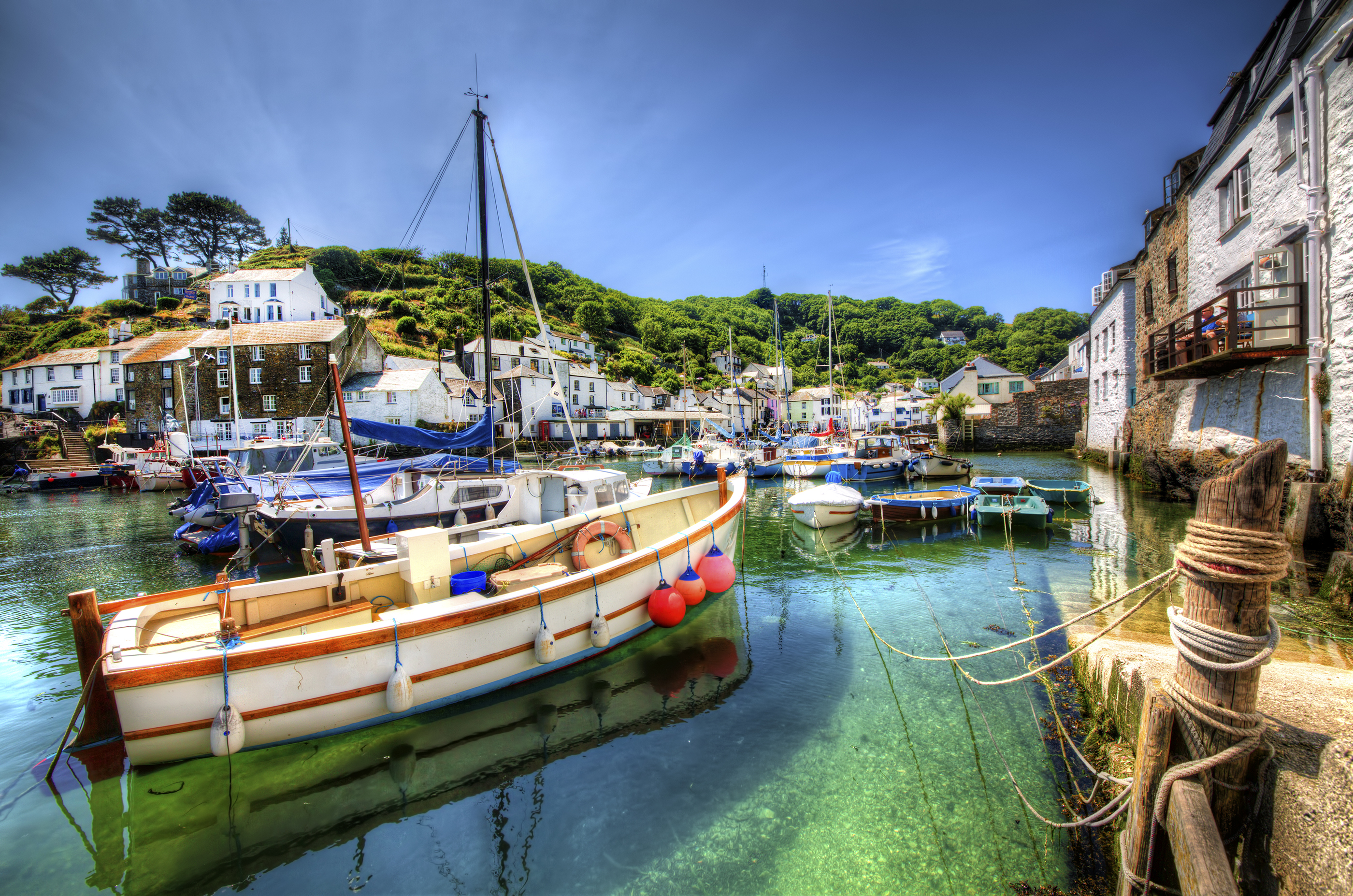 Smuk kystby Polperro i Cornwall med traditionelle fiskerbåde og charmerende engelske huse ved havnen