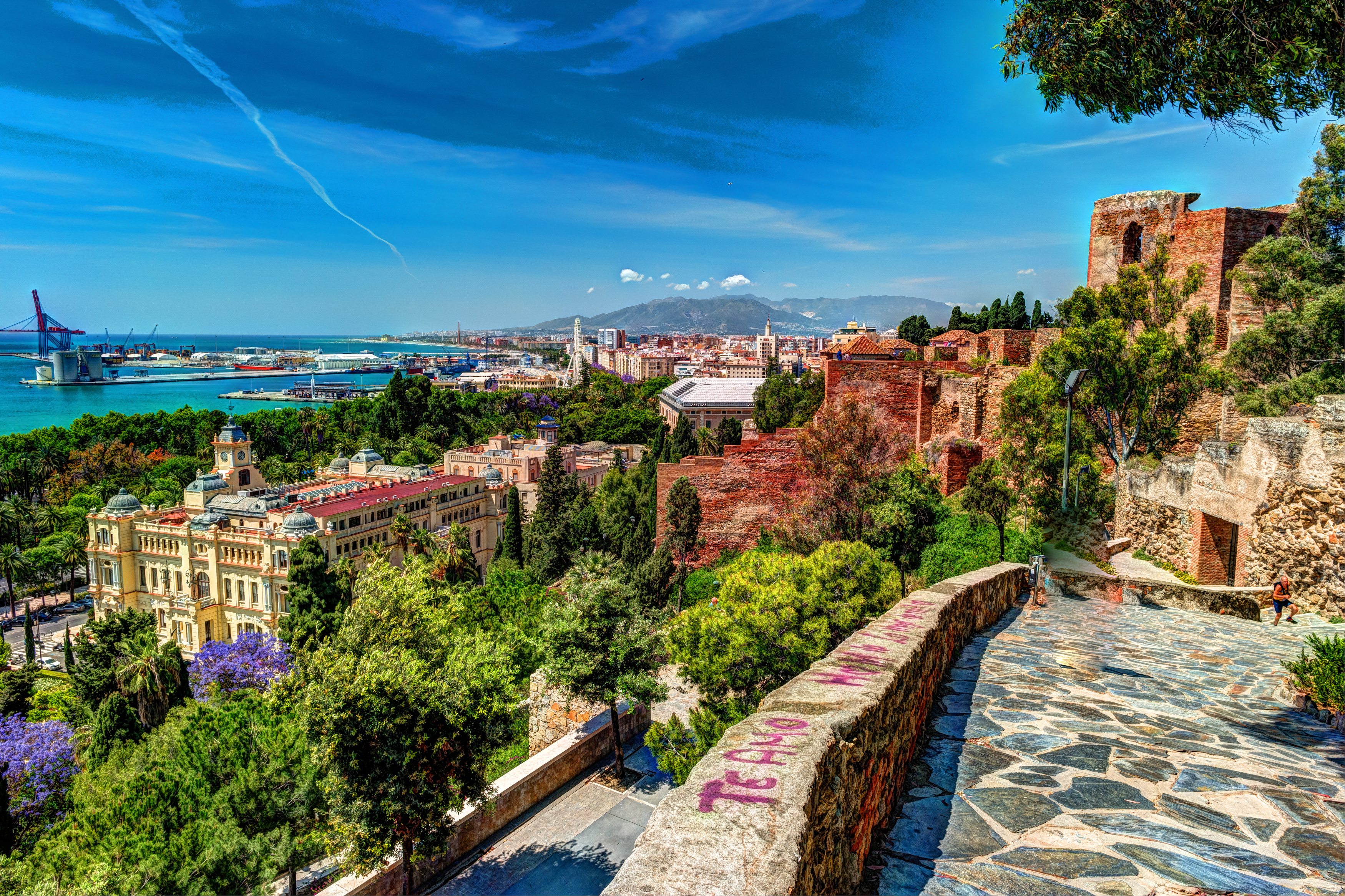 Charmerende luftperspektiv af Malaga på Costa del Sol, fotograferet fra Gibralfaro med byens ikoniske katedral, den mauriske Alcazaba og den blå havn