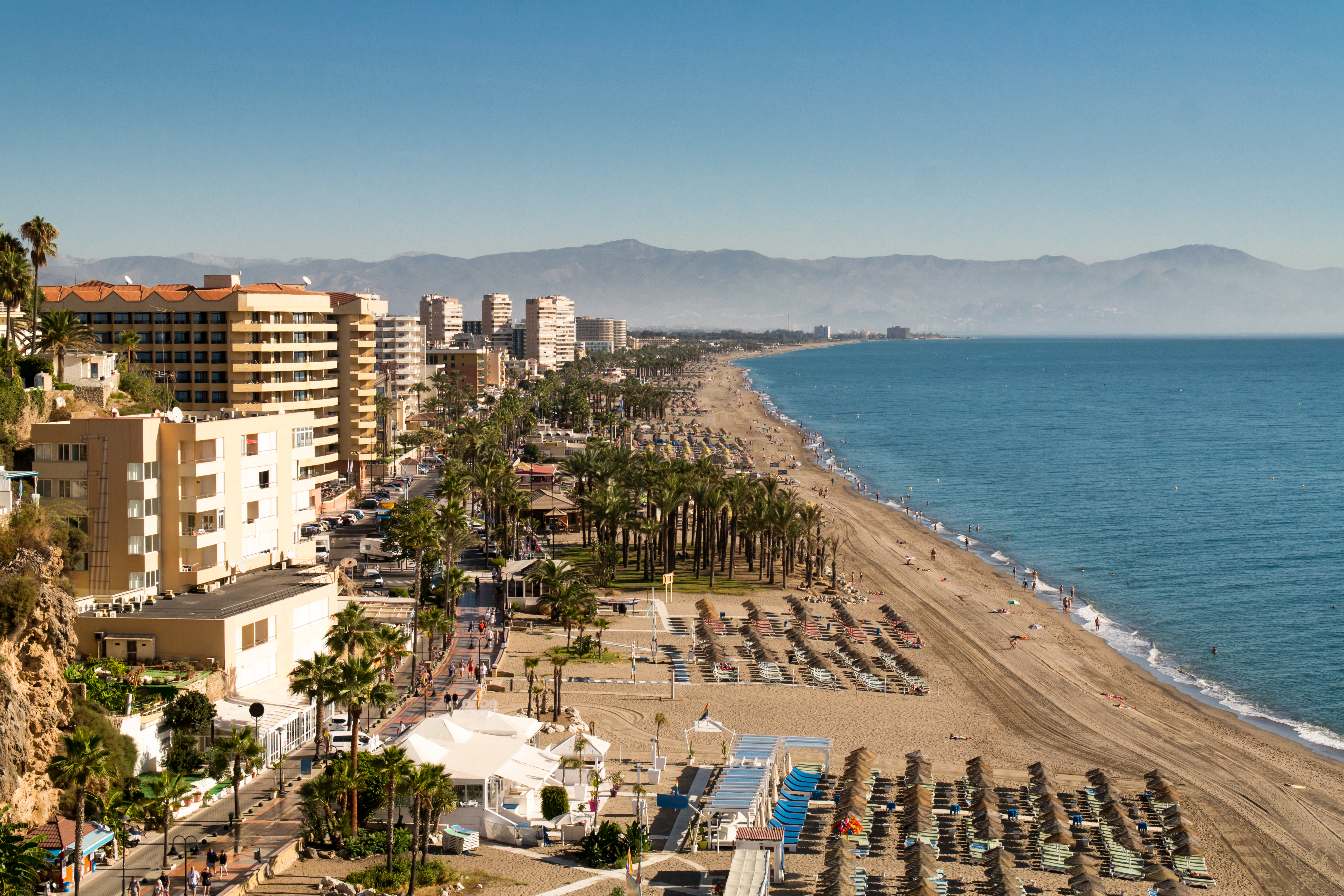 Flot udsigt over Torremolinos badeby med strand, hoteller og bjerglandskab bagved