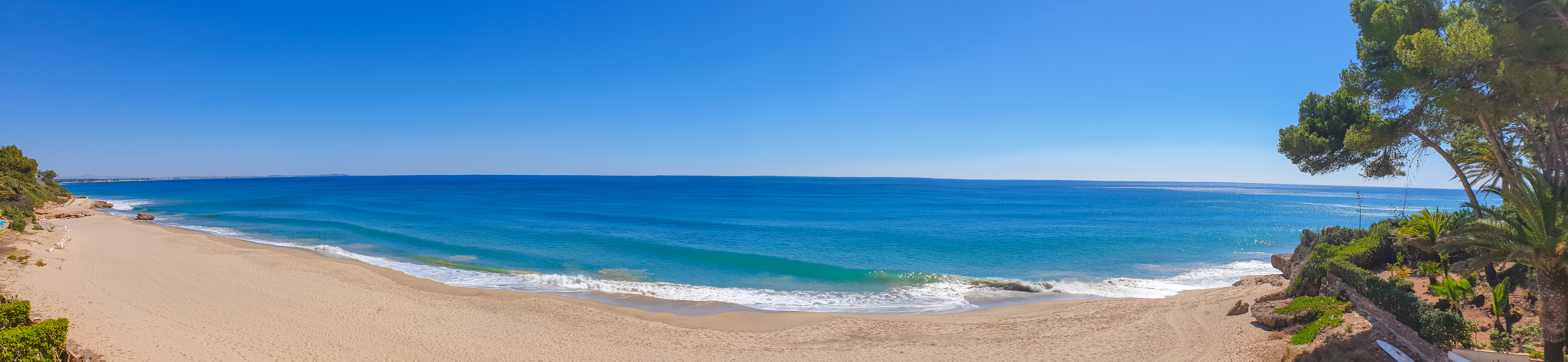 Idyllisk panoramaudsigt over Costa Doradas sandstrand med det smukke blå middelhav og grønne fyrretræer i Katalonien, Spanien