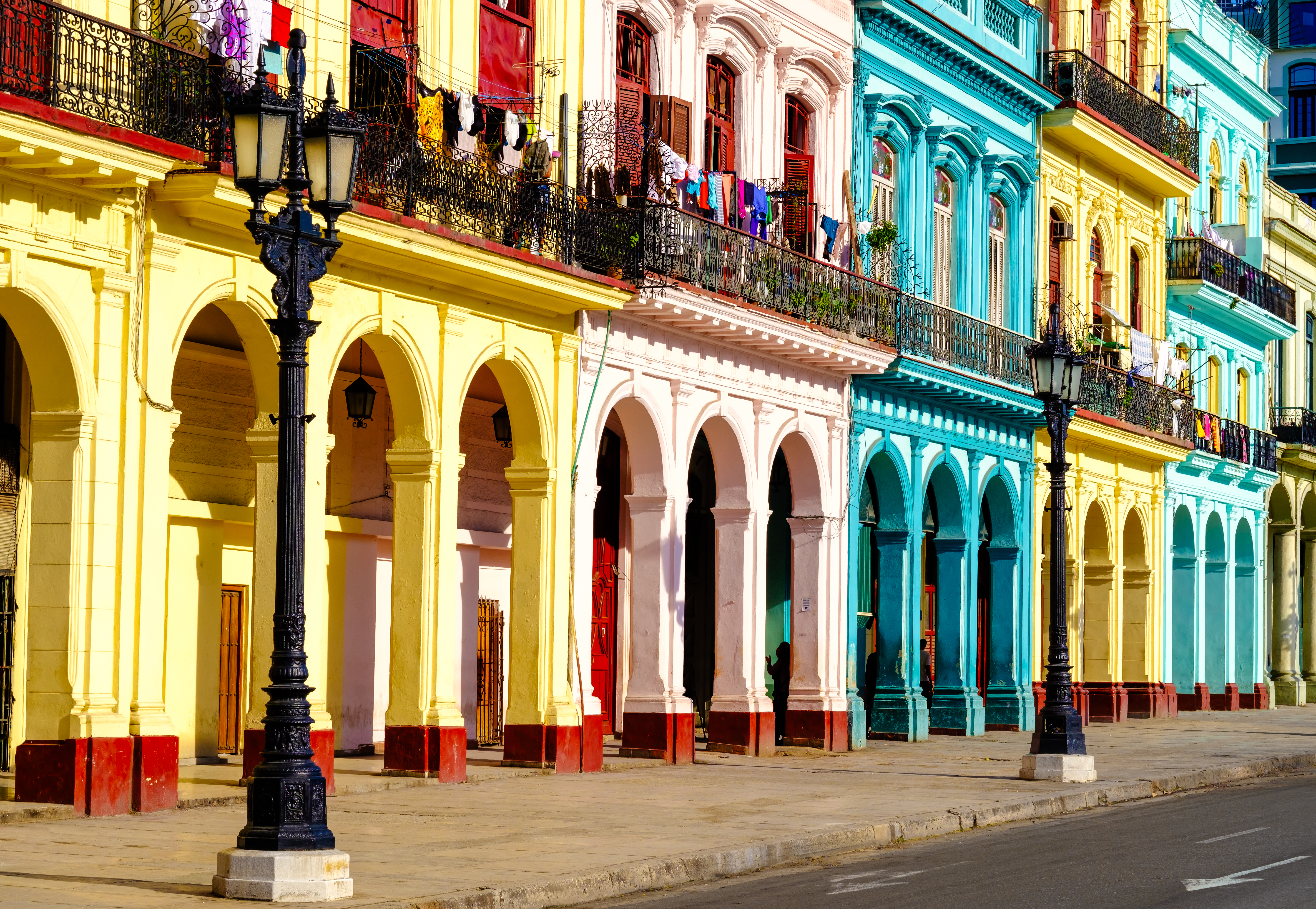 Typisk kubansk gadescene i Havana med farverige koloniale bygninger og traditionelle balkoner