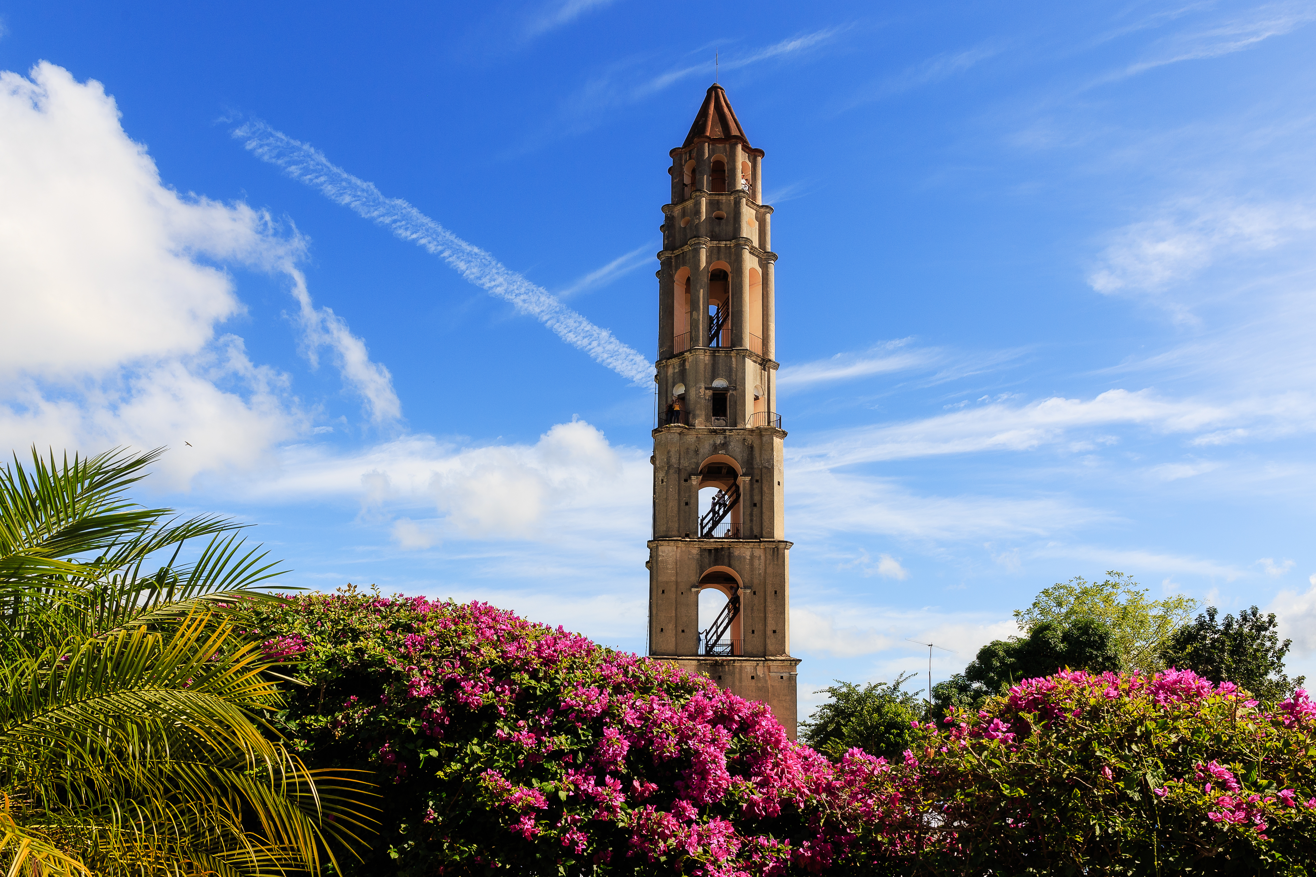 Ikonisk klokketårn i Trinidad Cuba med eksotiske blomster og caribisk atmosfære
