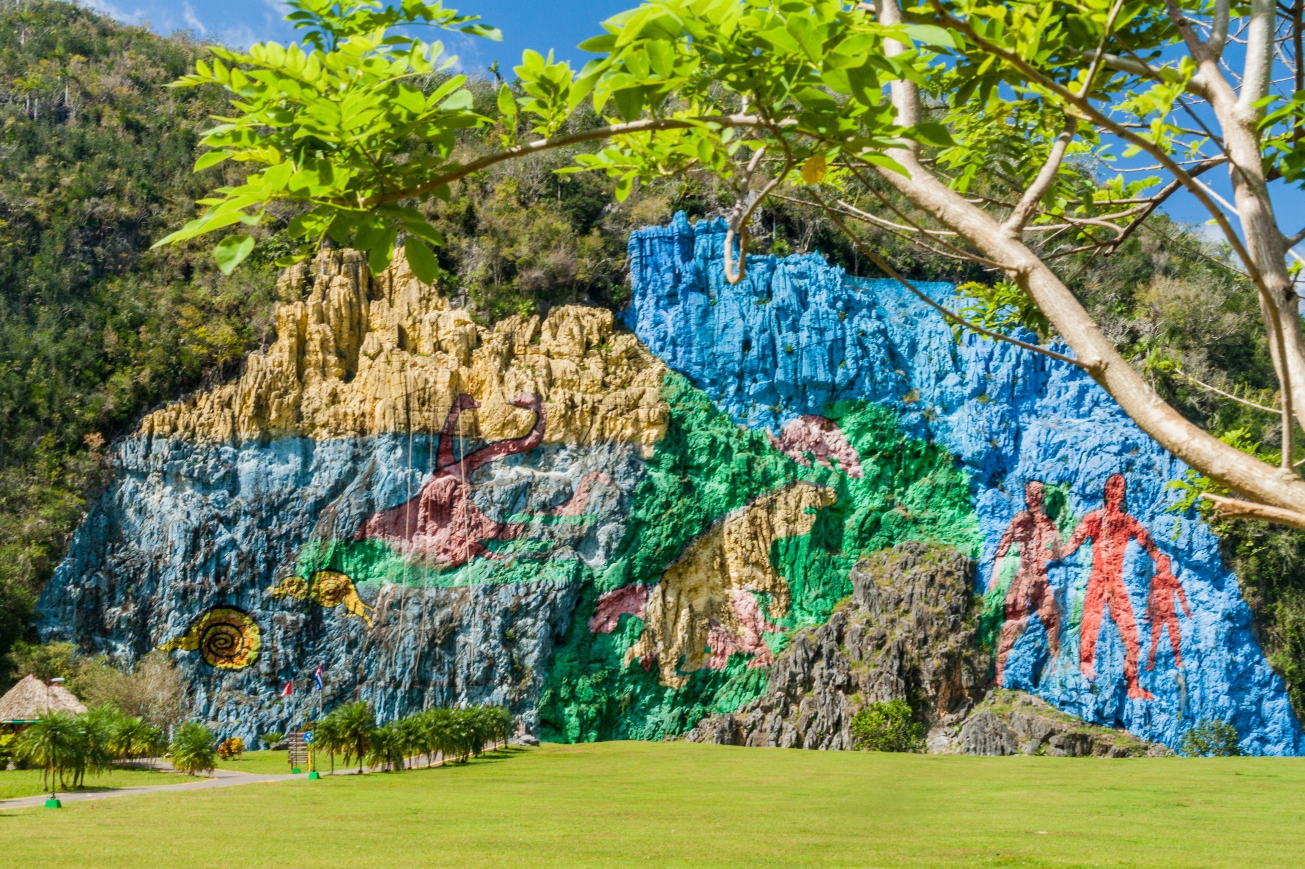 Berømt forhistorisk klippevægsmaleri i Viñales-dalen Cuba med blå himmel og tropisk vegetation