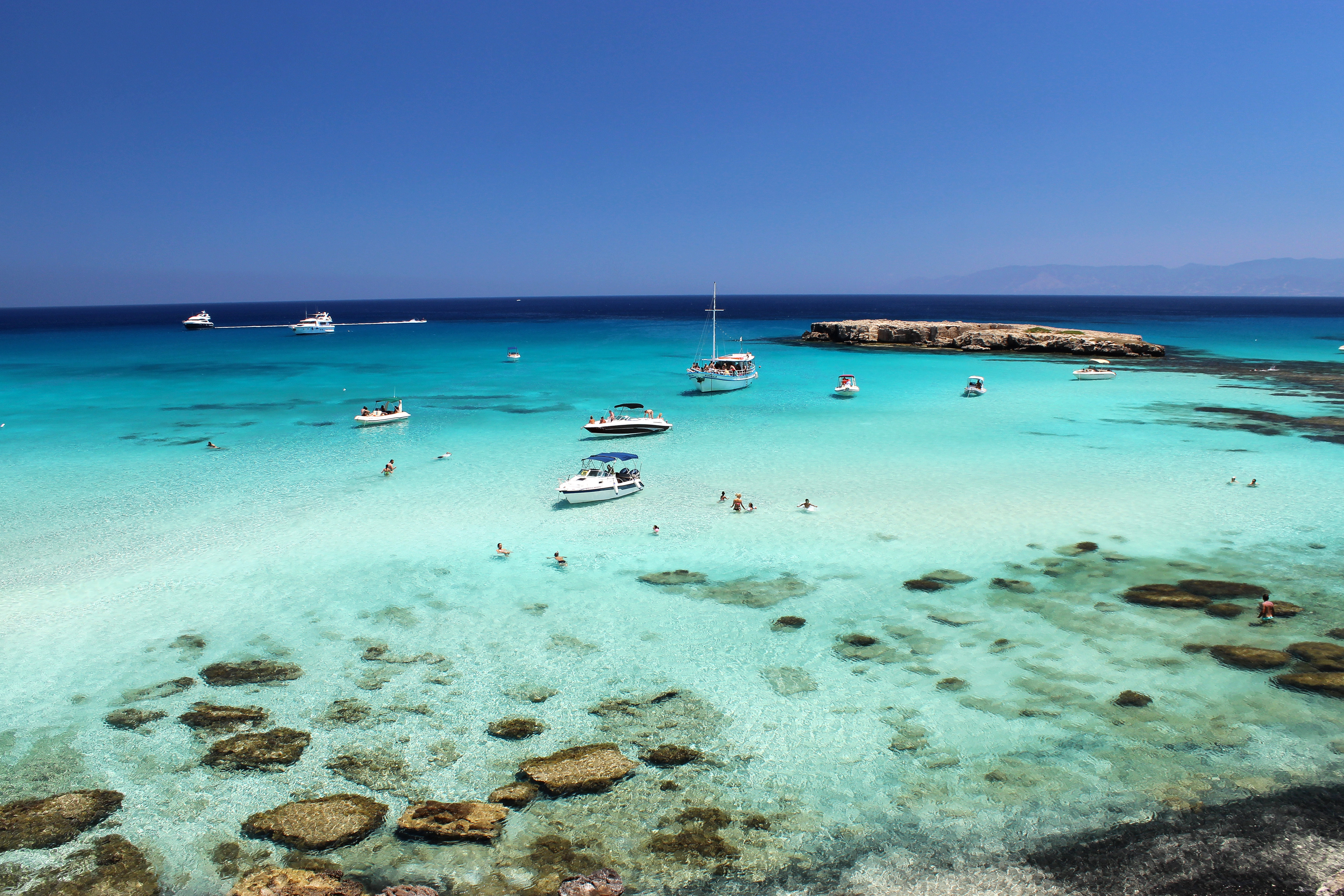 Paradisagtig Blue Lagoon på Cypern nær Paphos med krystalklart turkist vand, hvide både og koralrev i Akamas