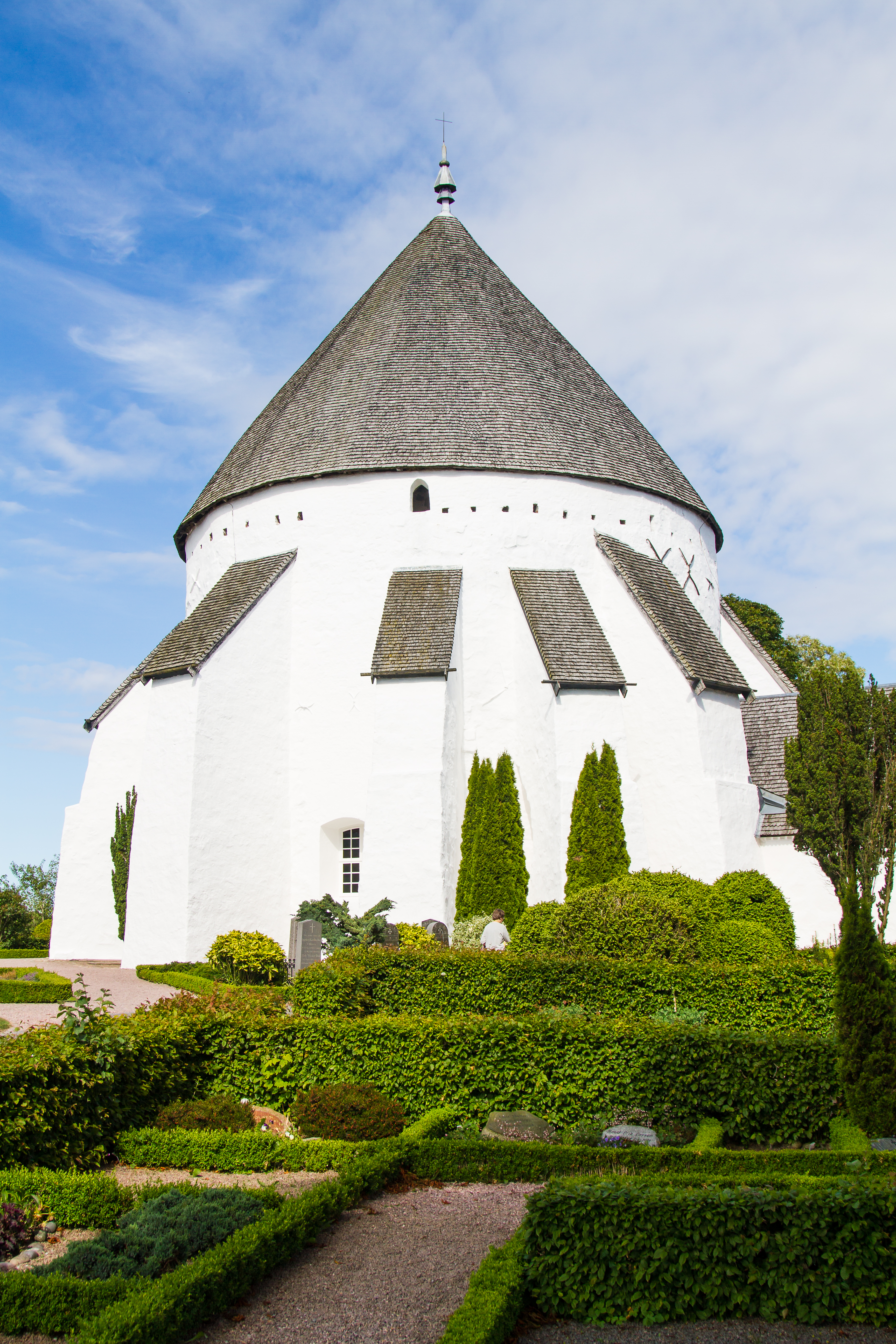Østerlars rundkirke omgivet af grønne hække på Bornholm