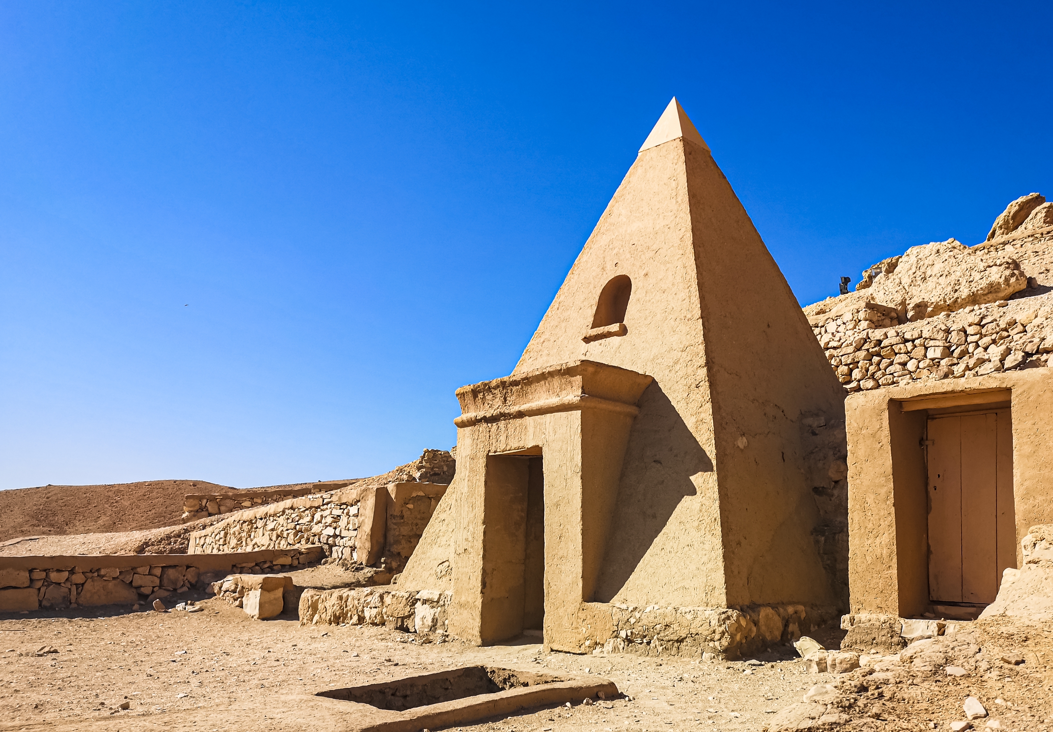 Ruinerne af håndværkernes by Deir el-Medina med karakteristiske pyramidegrave nær Luxor og Kongernes Dal i Egypten