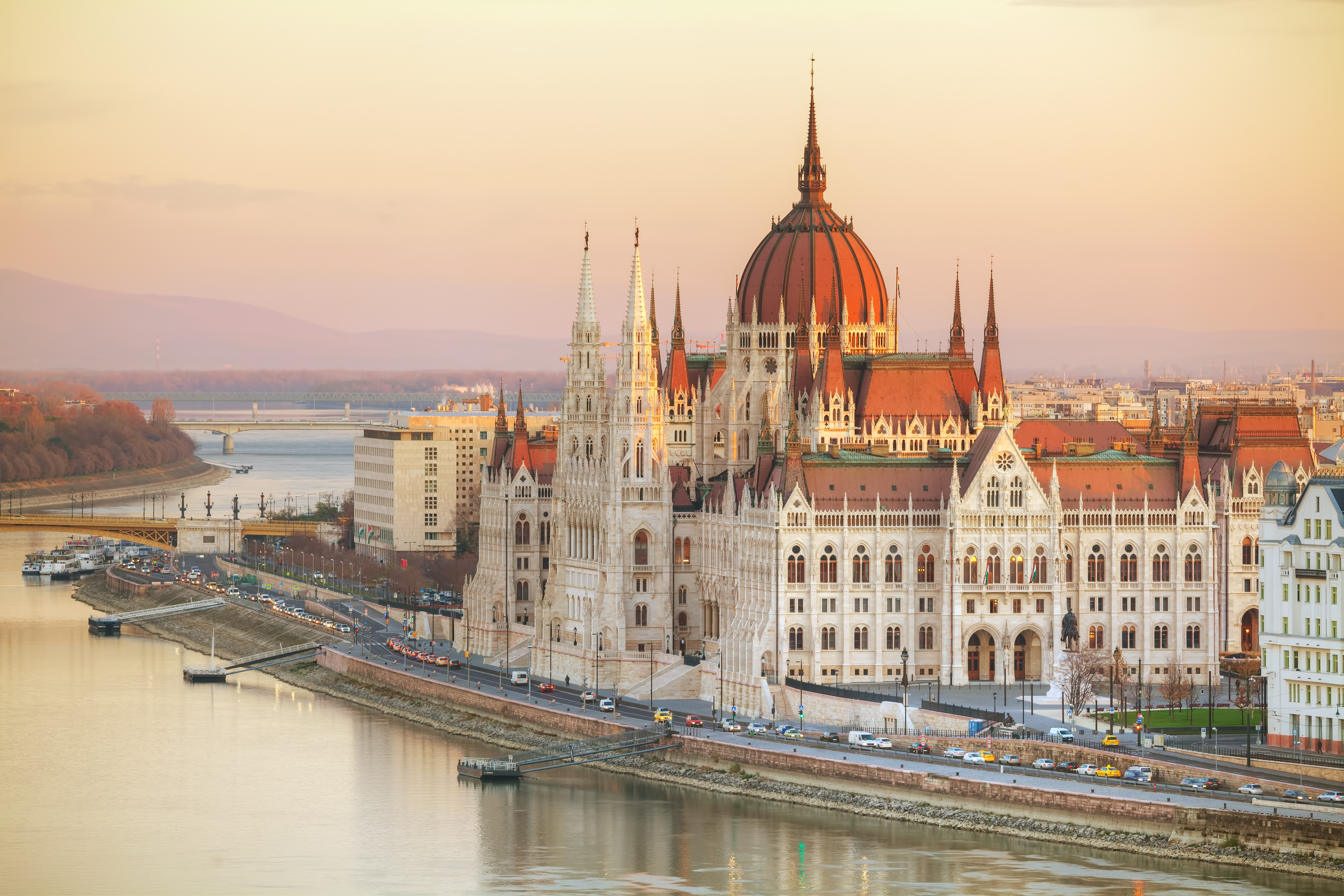 Parlamentsbygningen i Budapest ved Donau i Ungarn fotograferet ved solnedgang med gylden himmel