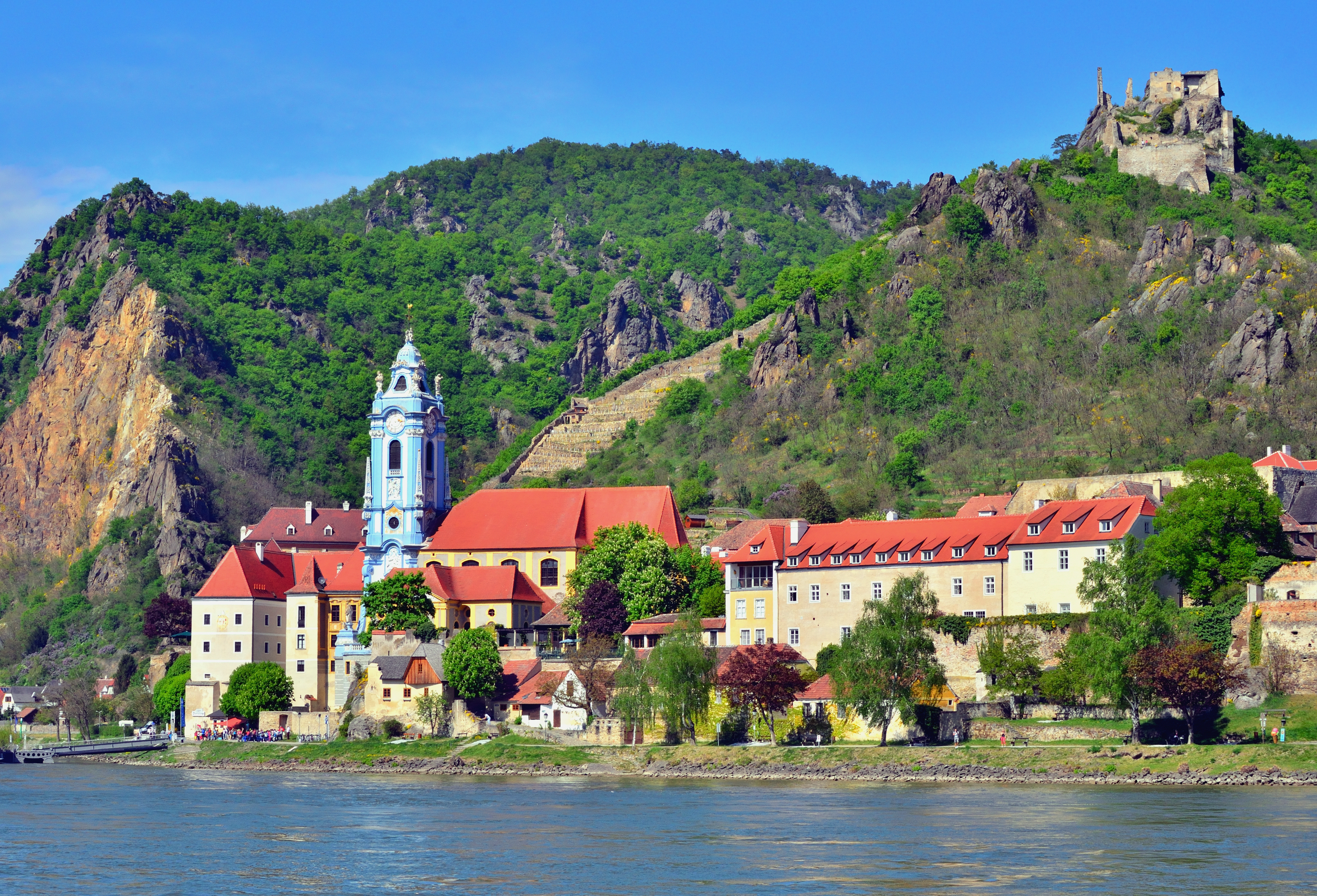 Charmerende Dürnstein klosterby med blåt tårn og borgруiner ved Donau i Østrigs Wachau region