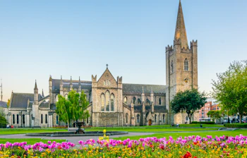 Stemningsfuldt aftenbillede af den historiske St. Patricks Katedral i Dublin med flot belysning - et ikonisk landemærke i Irland
