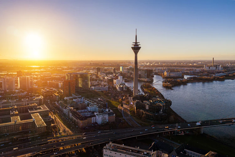 Betagende udsigt over Düsseldorfs skyline og Rhinen ved solnedgang set fra luften, Tyskland