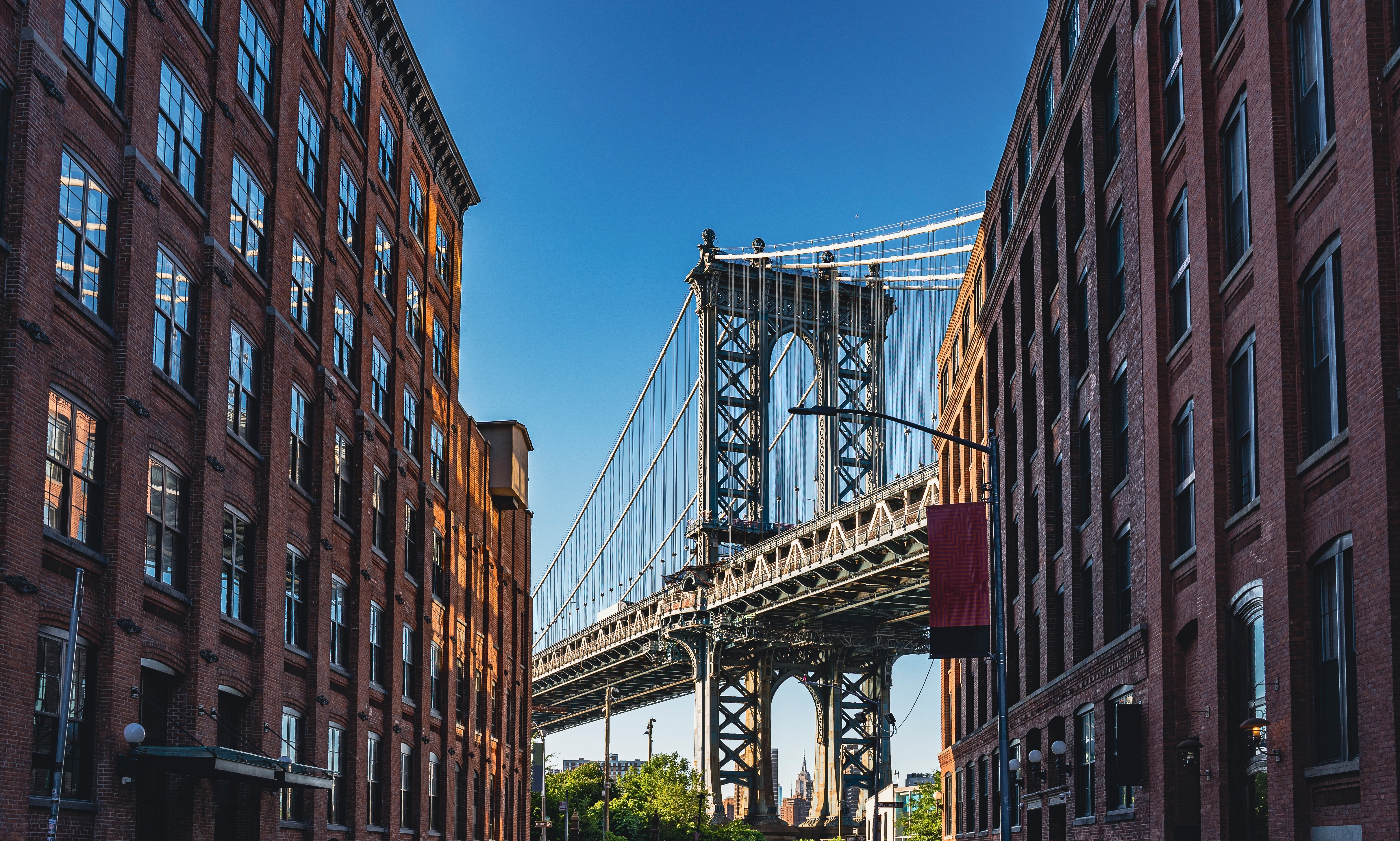 Klassisk Manhattan Bridge udsigt mellem historiske Brooklyn bygninger
