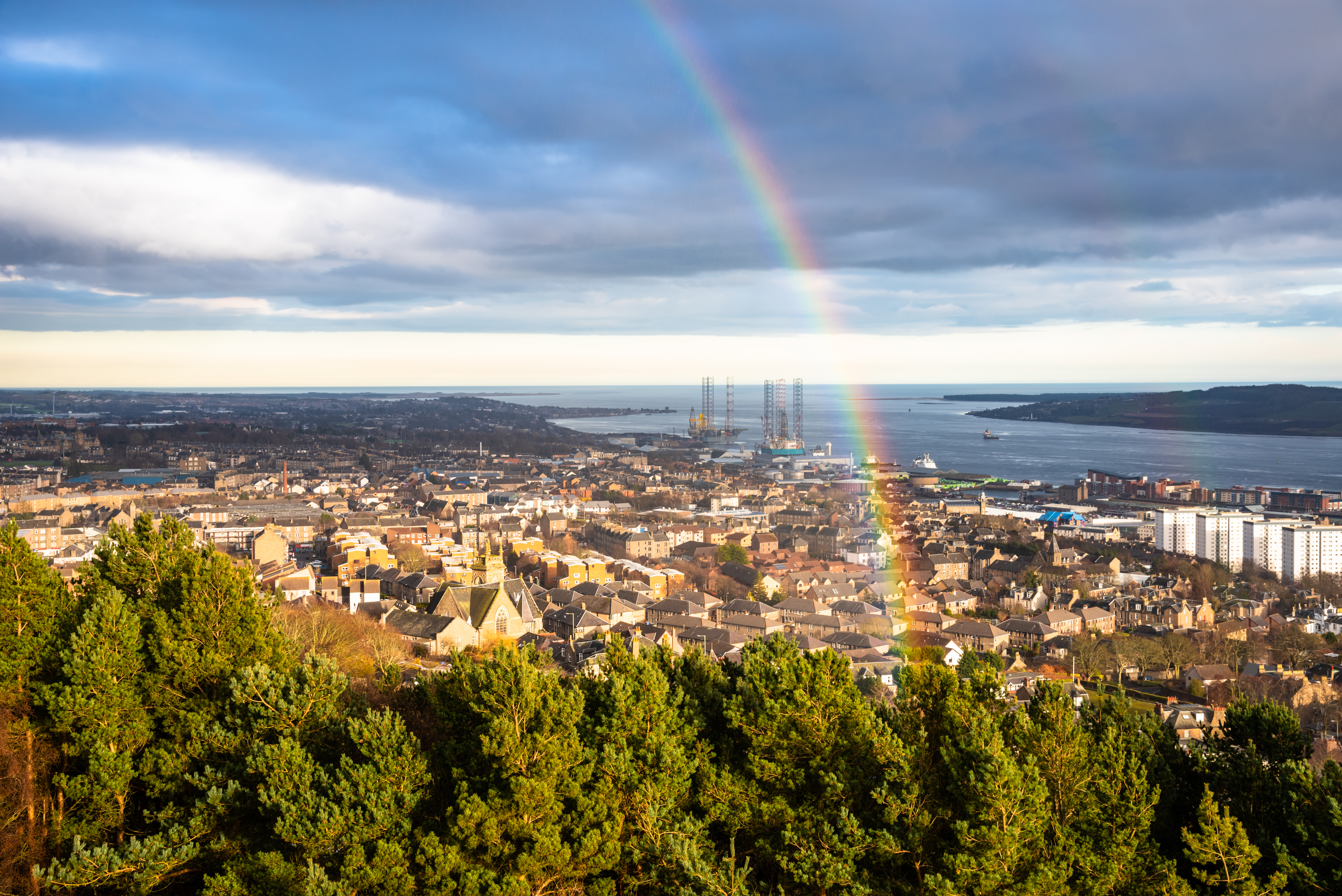 Malerisk udsigt over Dundee bycentrum med en flot regnbue over byen og Firth of Tay floden på en vinterdag i Skotland