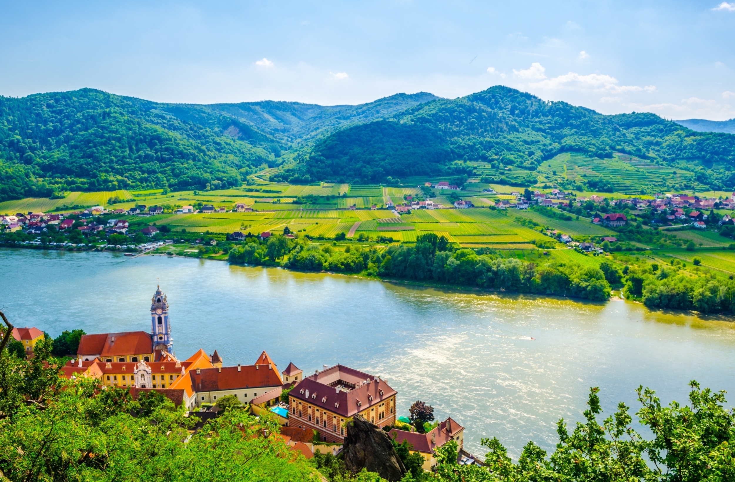 Betagende luftfoto af Dürnstein by omgivet af frodige vinmarker langs Donau-floden i Wachau-dalen - en perle på vores Østrig-rejser