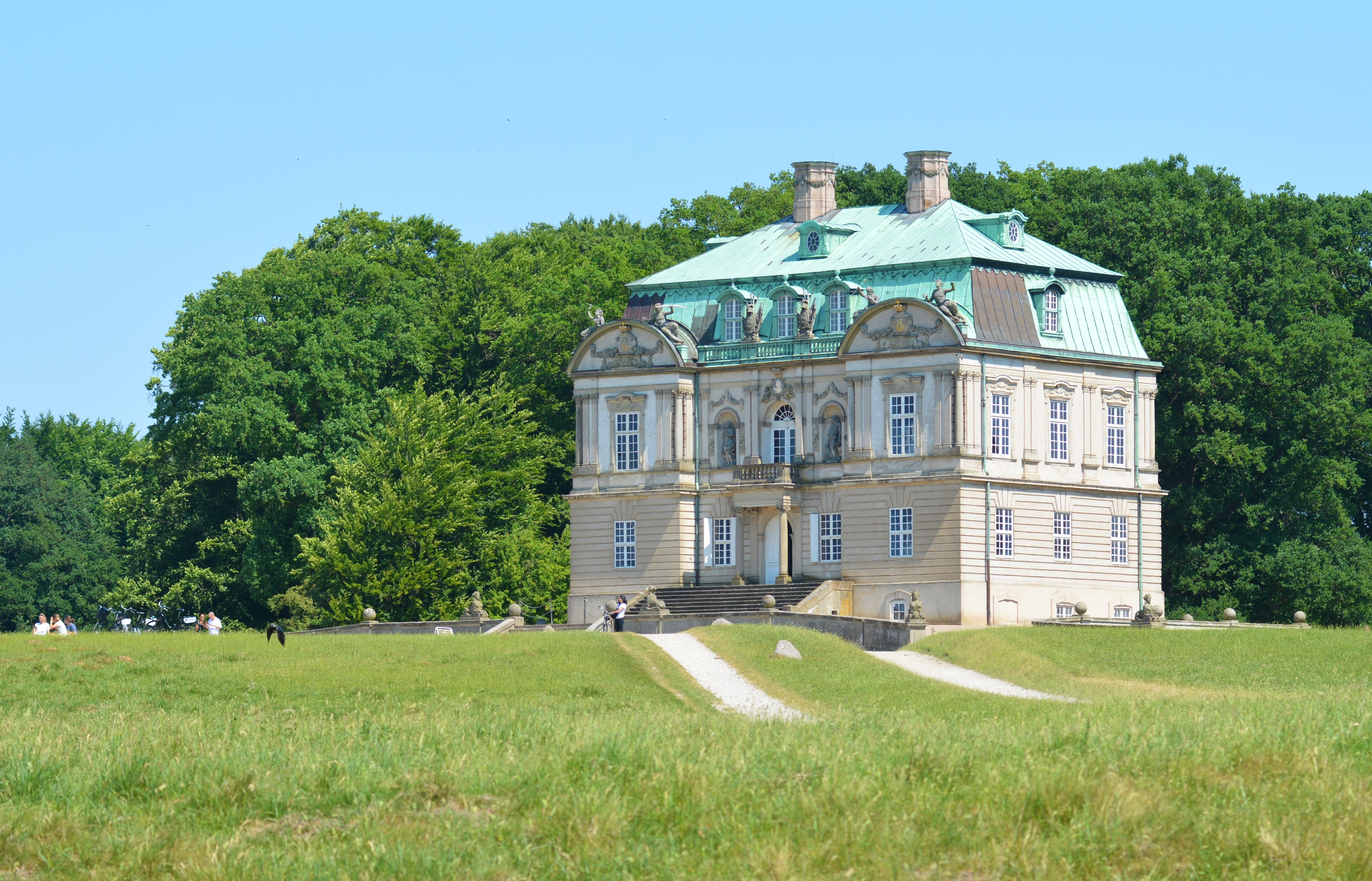 Eremitagen jagtslot i Dyrehaven ved Klampenborg med grønne enge og skov på en solrig sommerdag