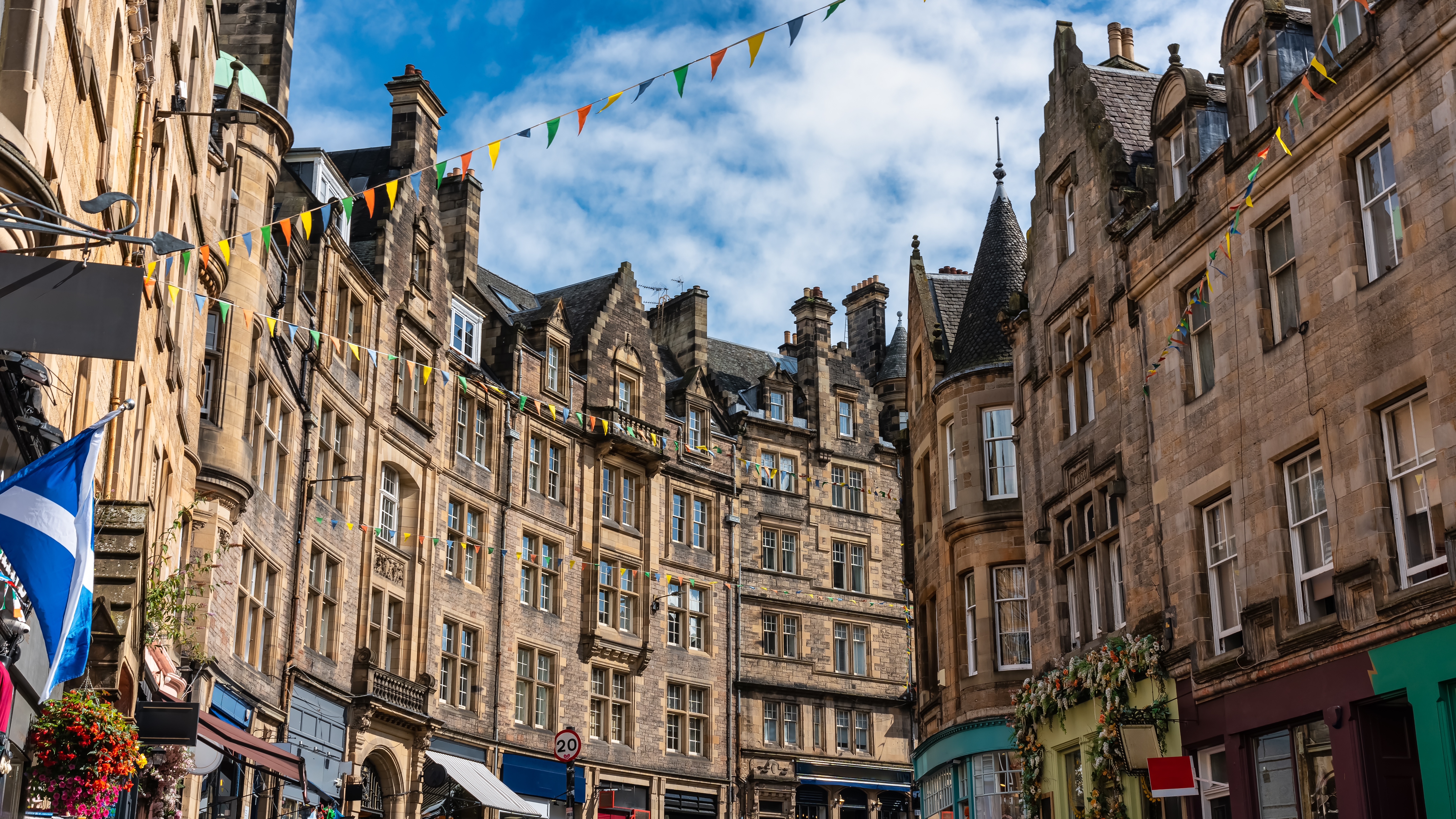 Den smukke og historiske Royal Mile i Edinburghs gamle bydel med middelalderlige bygninger og farverige flag