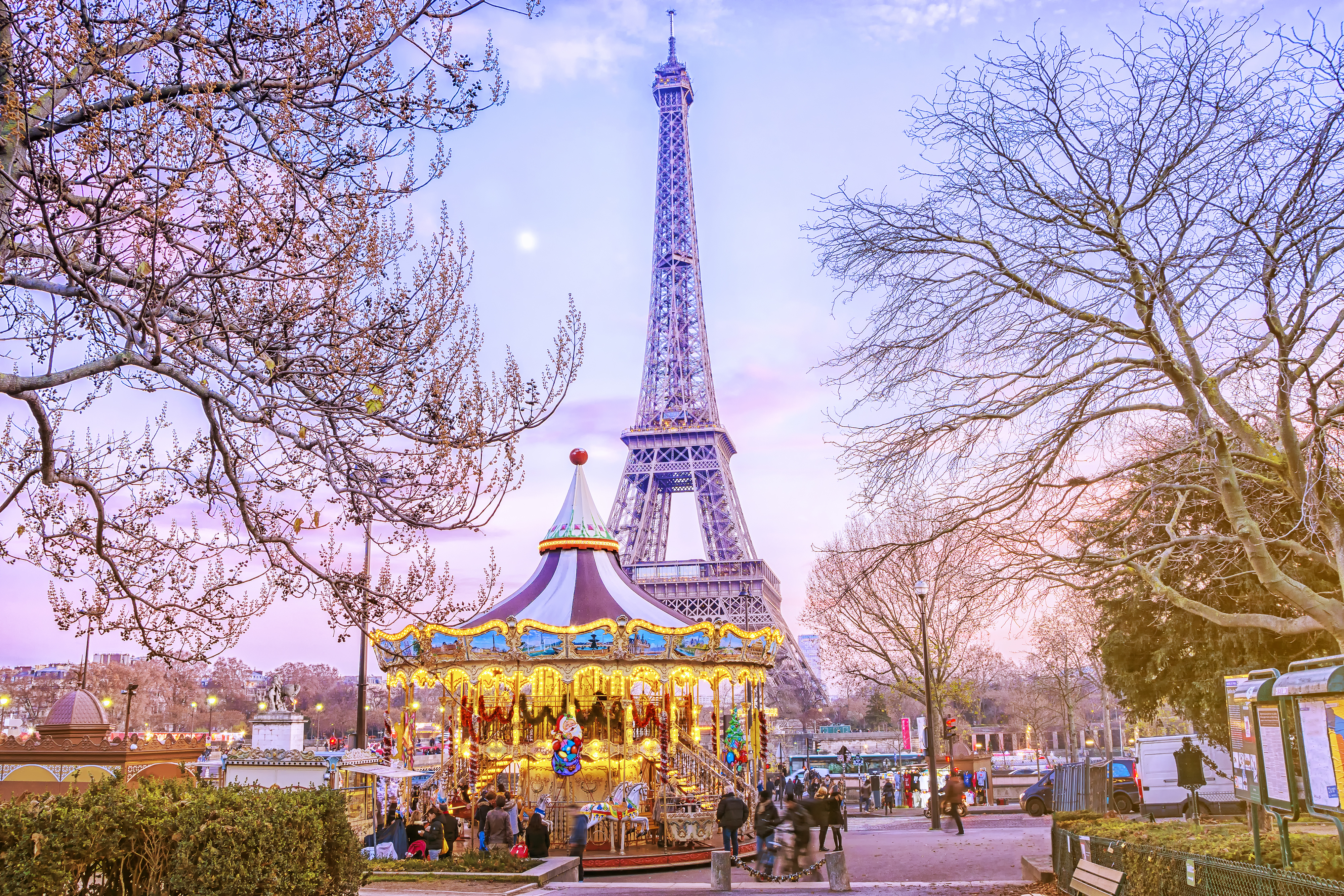 Romantisk vinteraften i Paris med oplyst karrusel og Eiffeltårnet i baggrunden