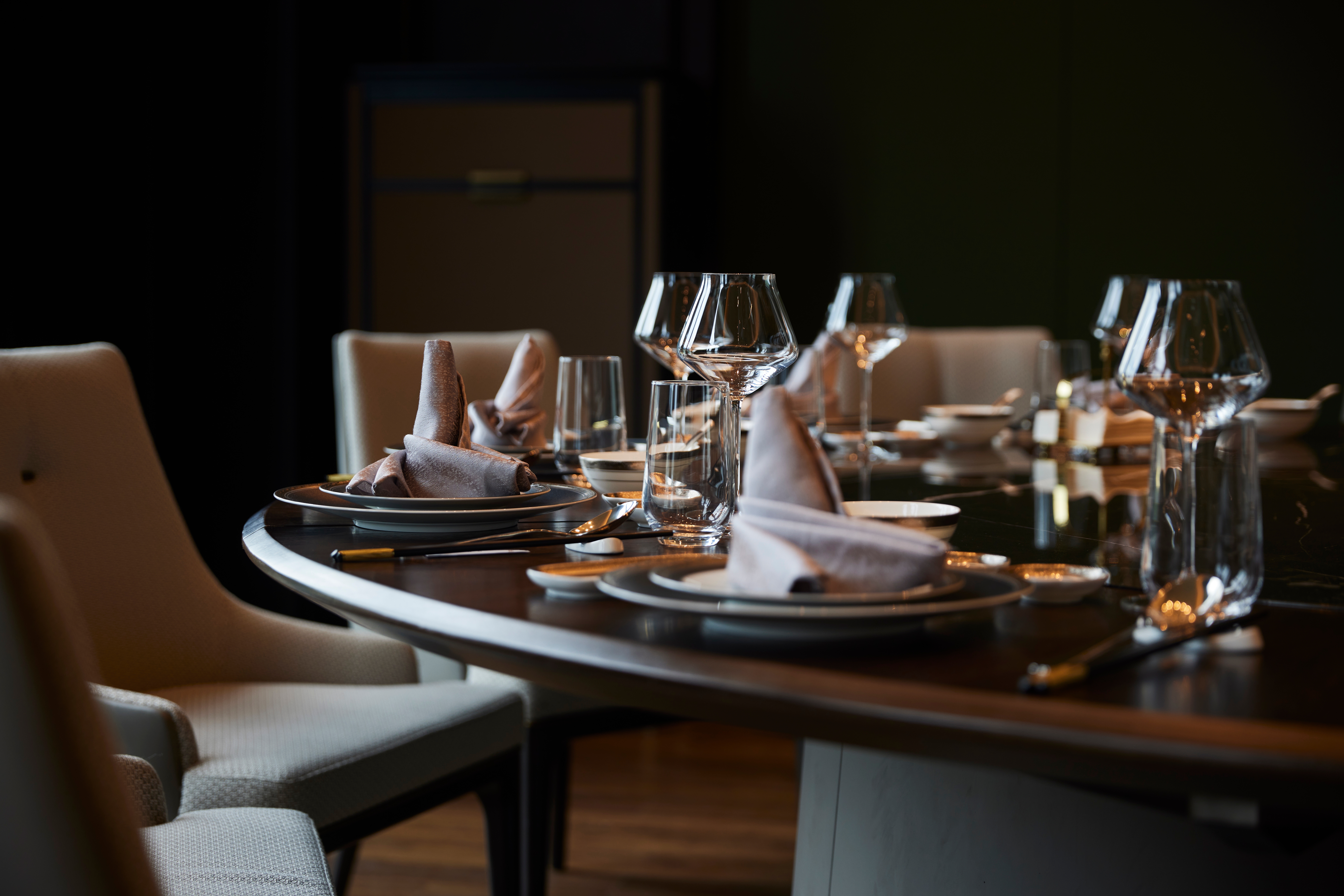 Eksklusivt dækket bord med krystalglas og foldede servietter i luksuriøst privat restaurantlokale