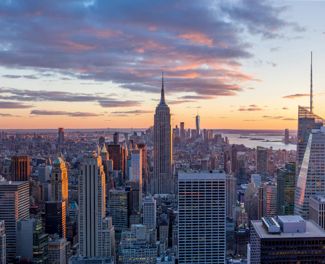 Empire State Building og Manhattan panorama ved skumringstid med oplyste kontorbygninger