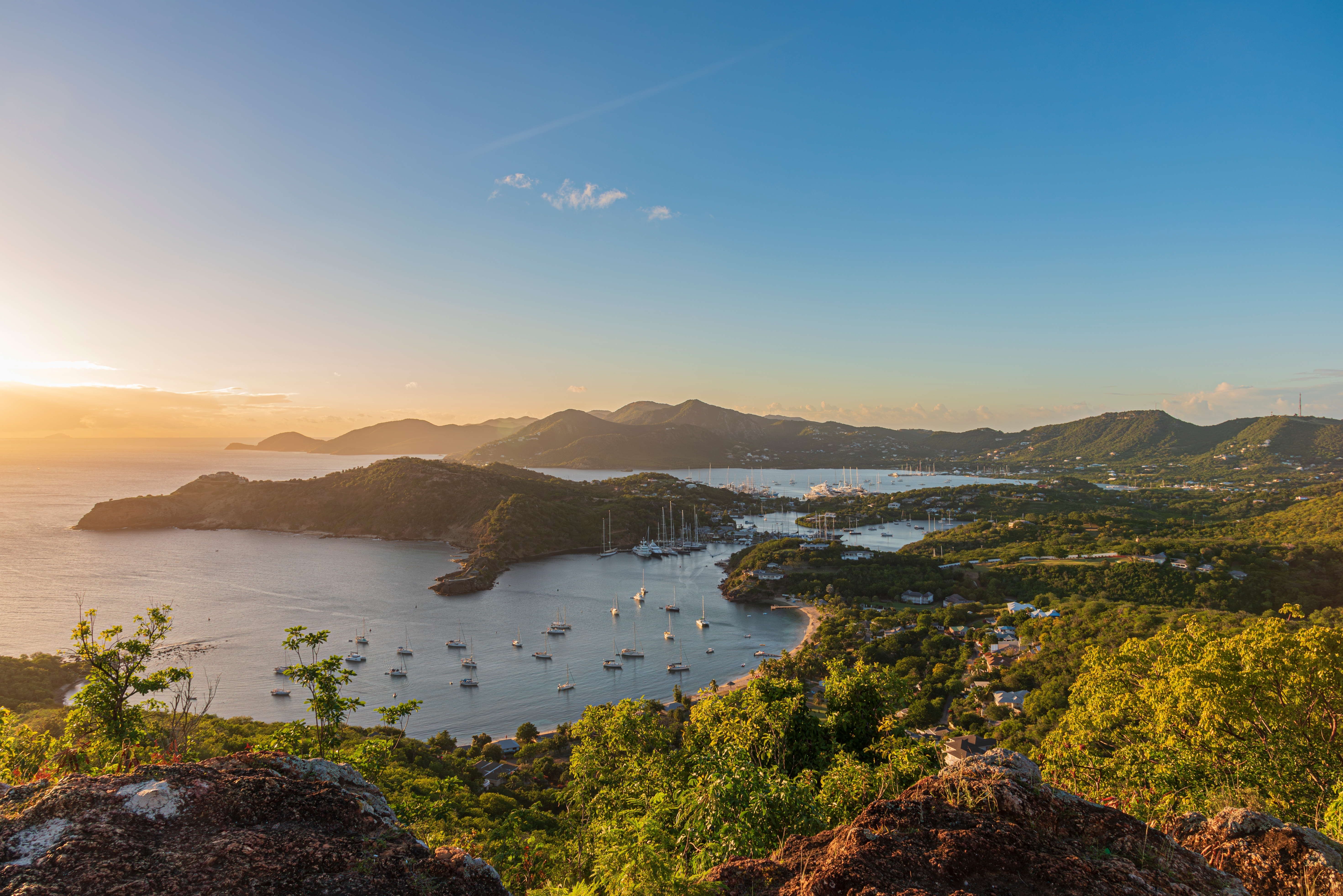 English Harbour i Antigua med forankrede sejlbåde og dramatisk caribisk solnedgang