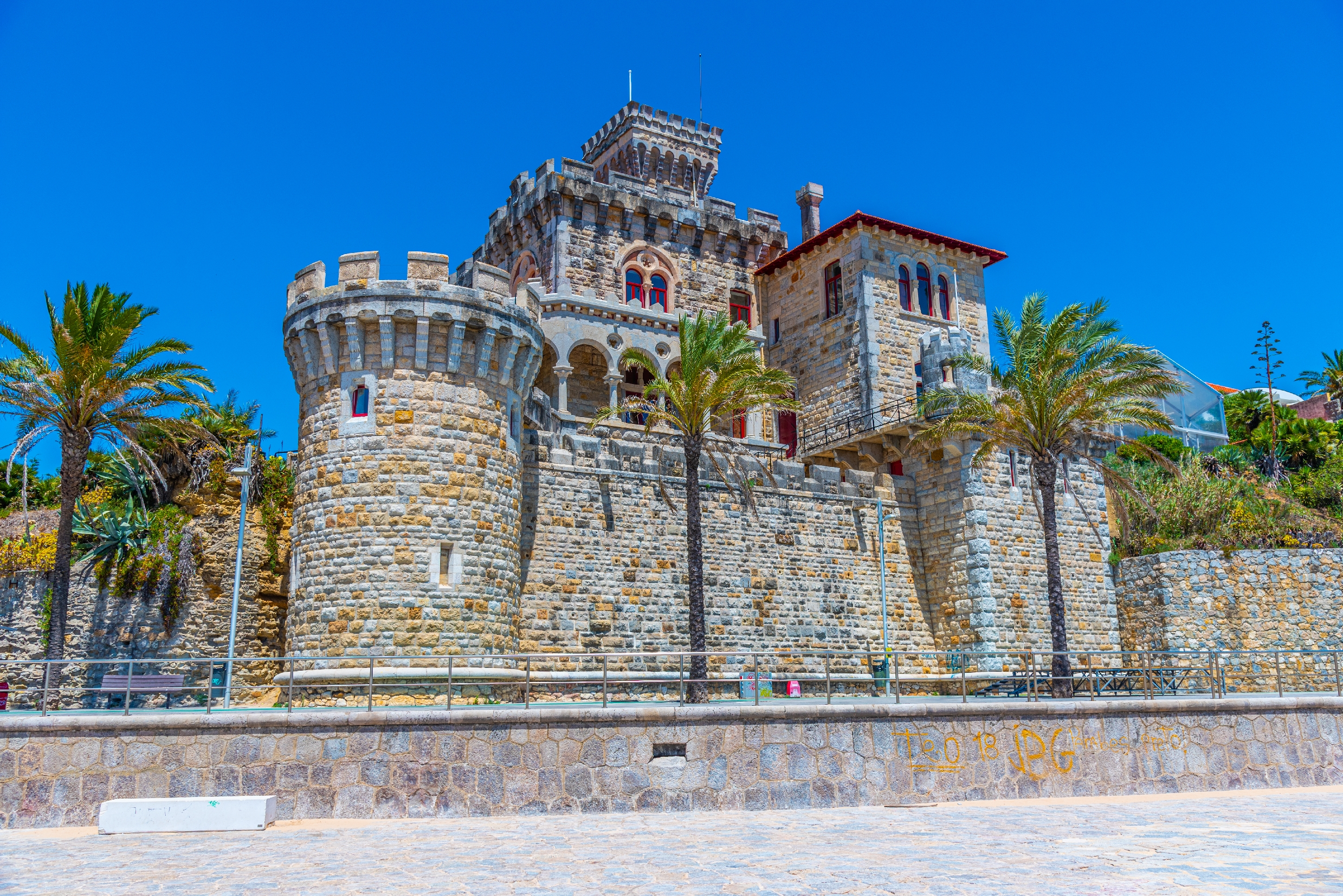 Charmerende historisk kastel med battlements og palmer på den solrige portugisiske Riviera i Estoril