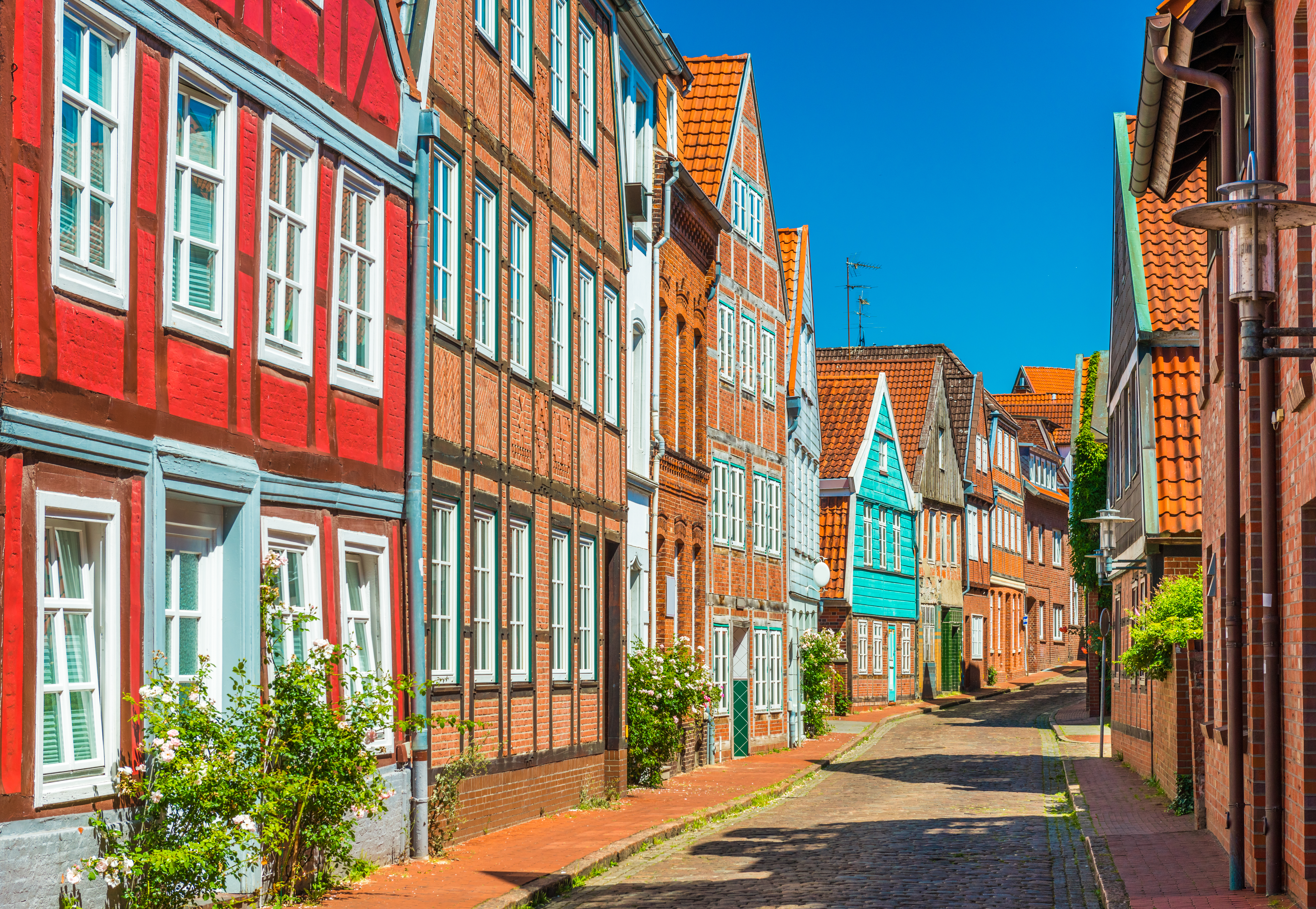 Europæisk bindingsværk arkitektur med røde og blå huse på smal gade