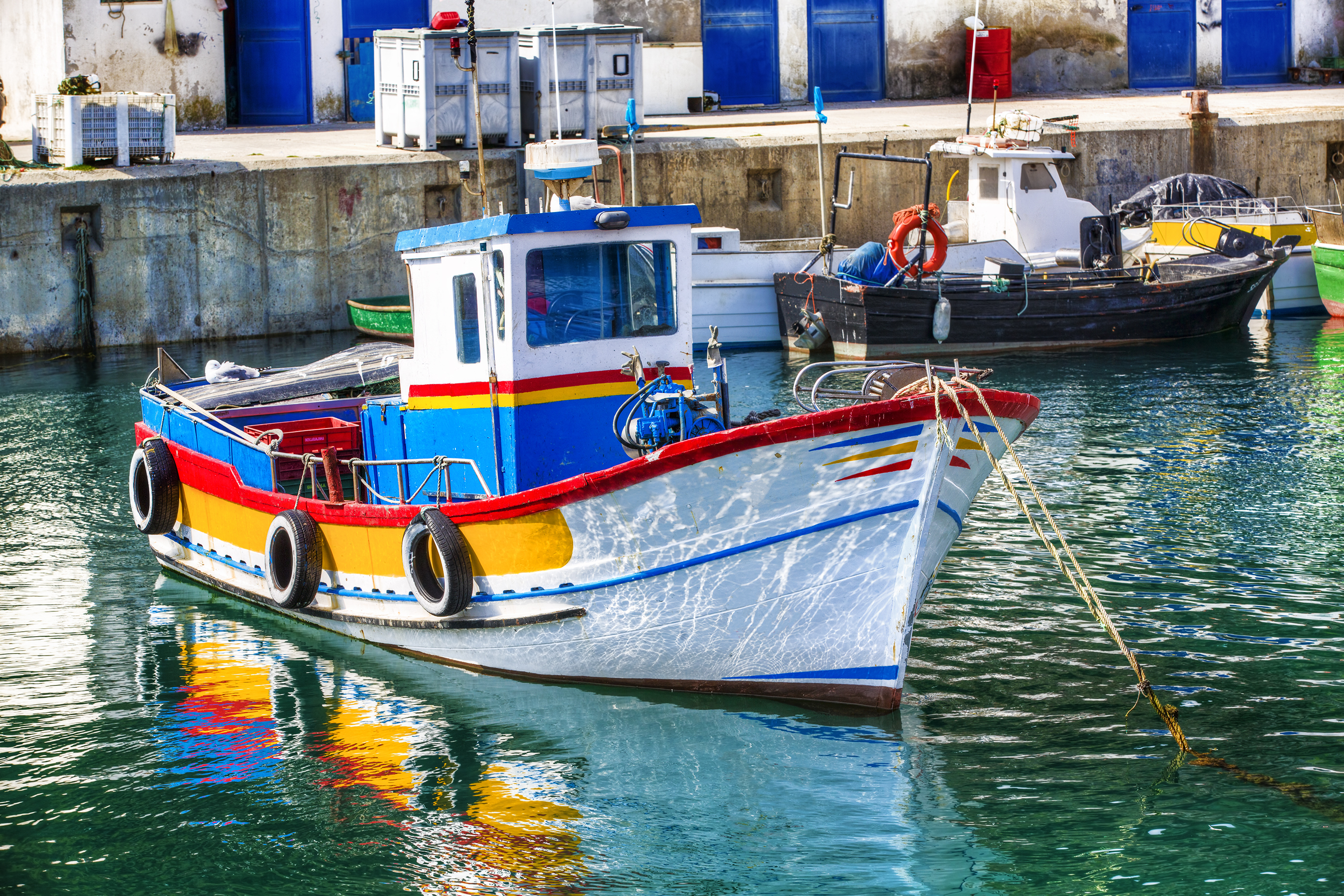 Europæiske fiskerbåde med farverige skrog i autentisk portugisisk fiskerihavn
