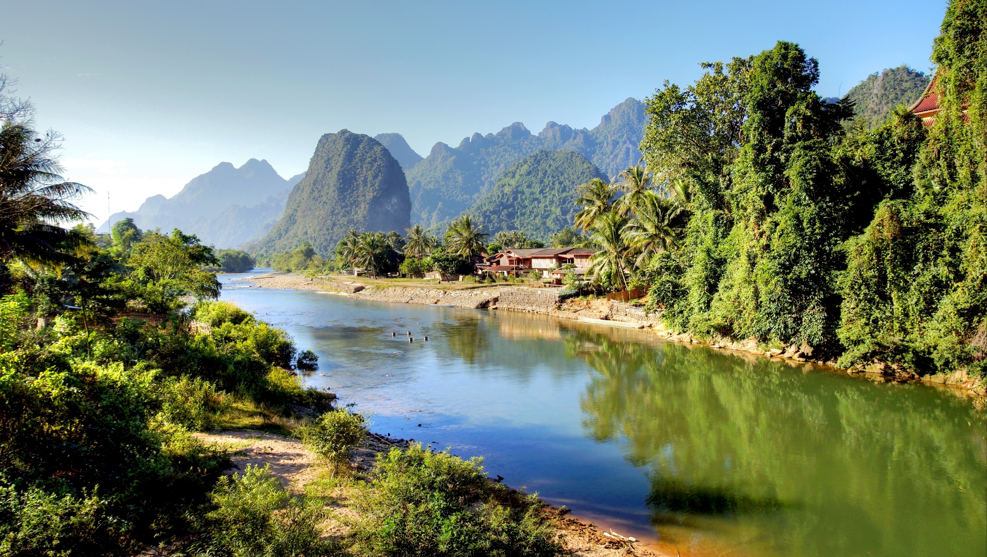 Fantastisk natursceneri ved Song-floden med grønne bjerge og jungle i Vang Vieng, Laos - et must-see på rejsen til Sydøstasien
