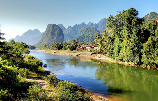 Fantastisk natursceneri ved Song-floden med grønne bjerge og jungle i Vang Vieng, Laos - et must-see på rejsen til Sydøstasien