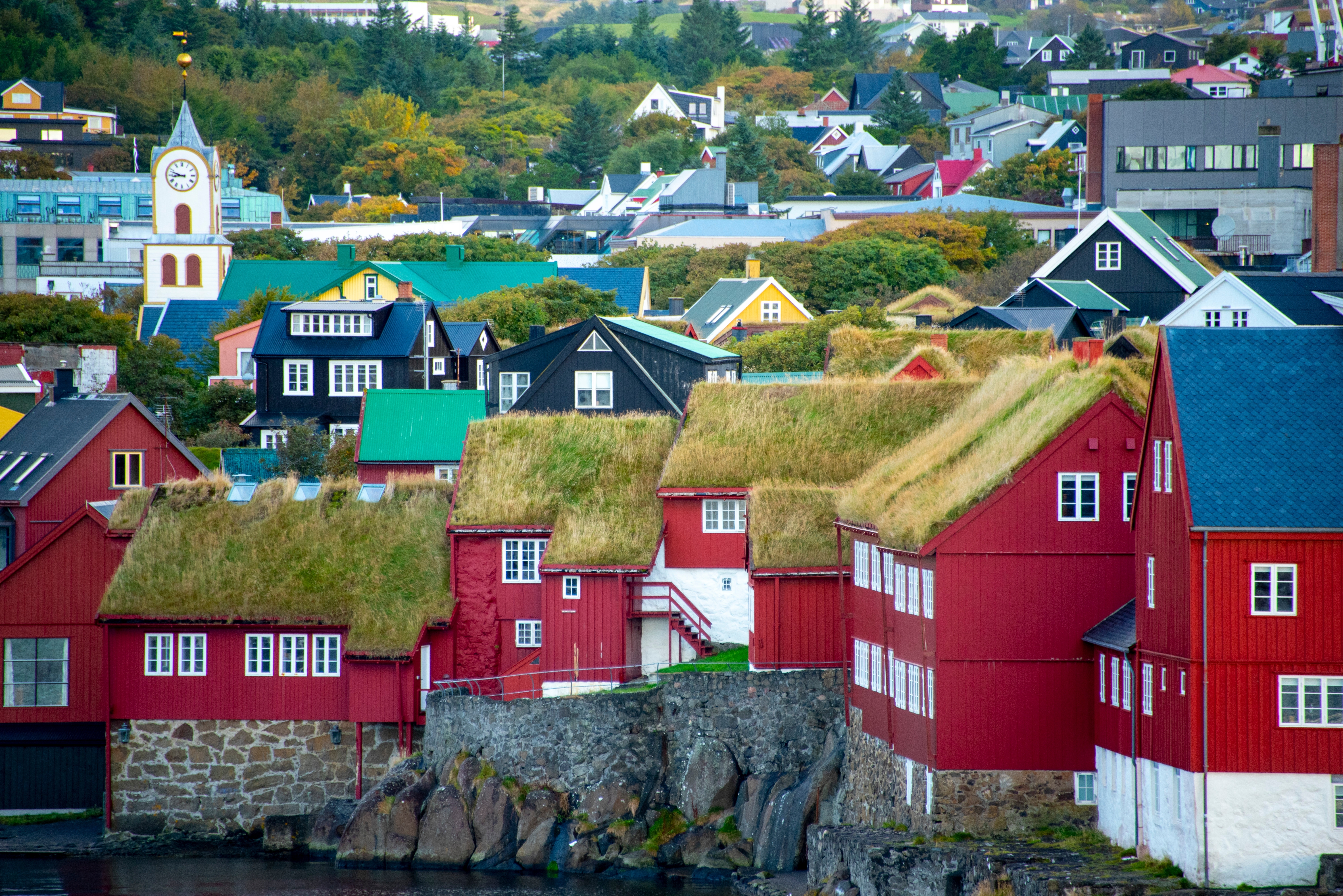 Charmerende røde huse med traditionelle græstage i Tinganes, den historiske bydel i Torshavn på Færøerne