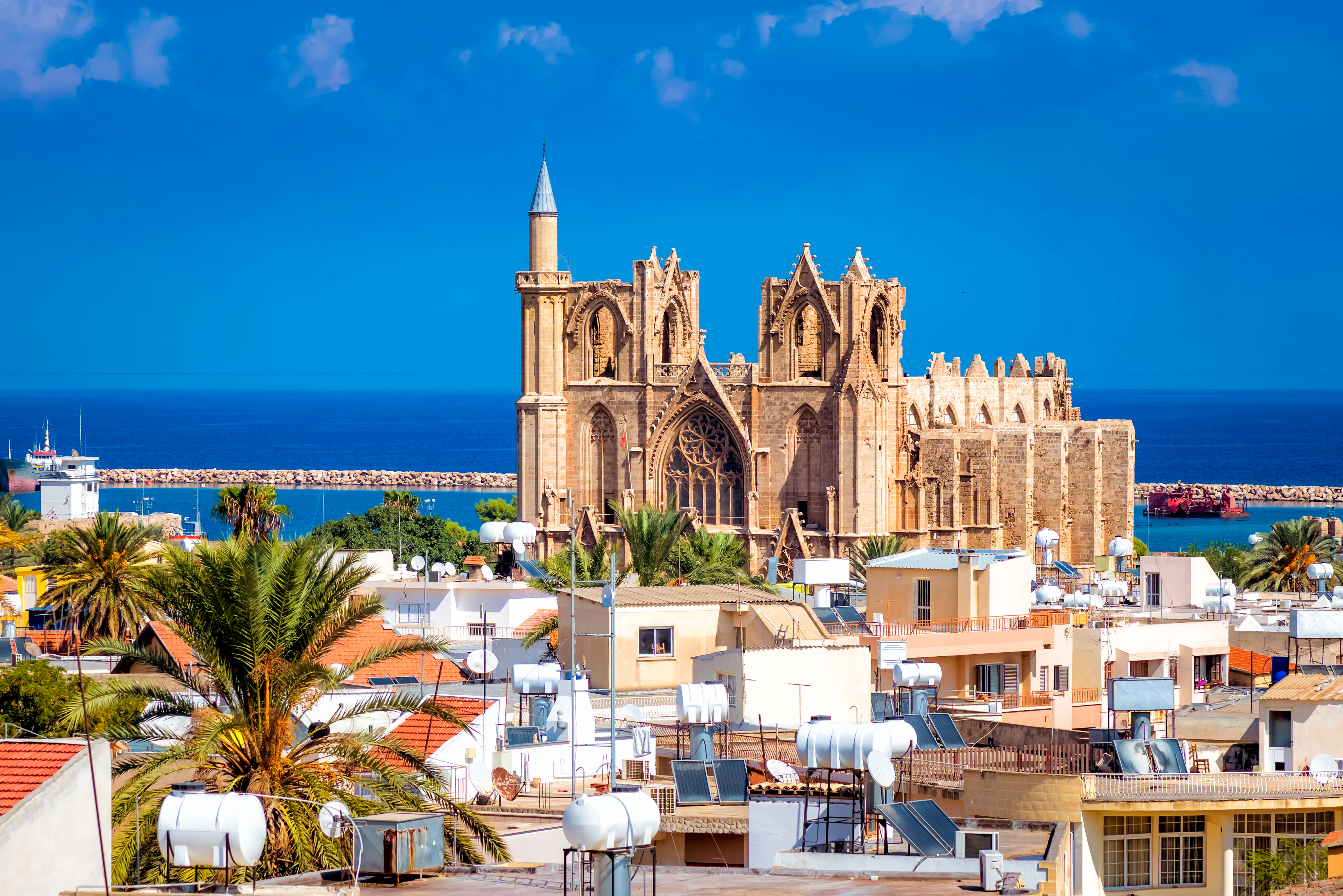 Den tidligere St. Nikolaus-katedral, nu Lala Mustafa Pasha-moskeen, i Famagusta med blå himmel og hav i baggrunden