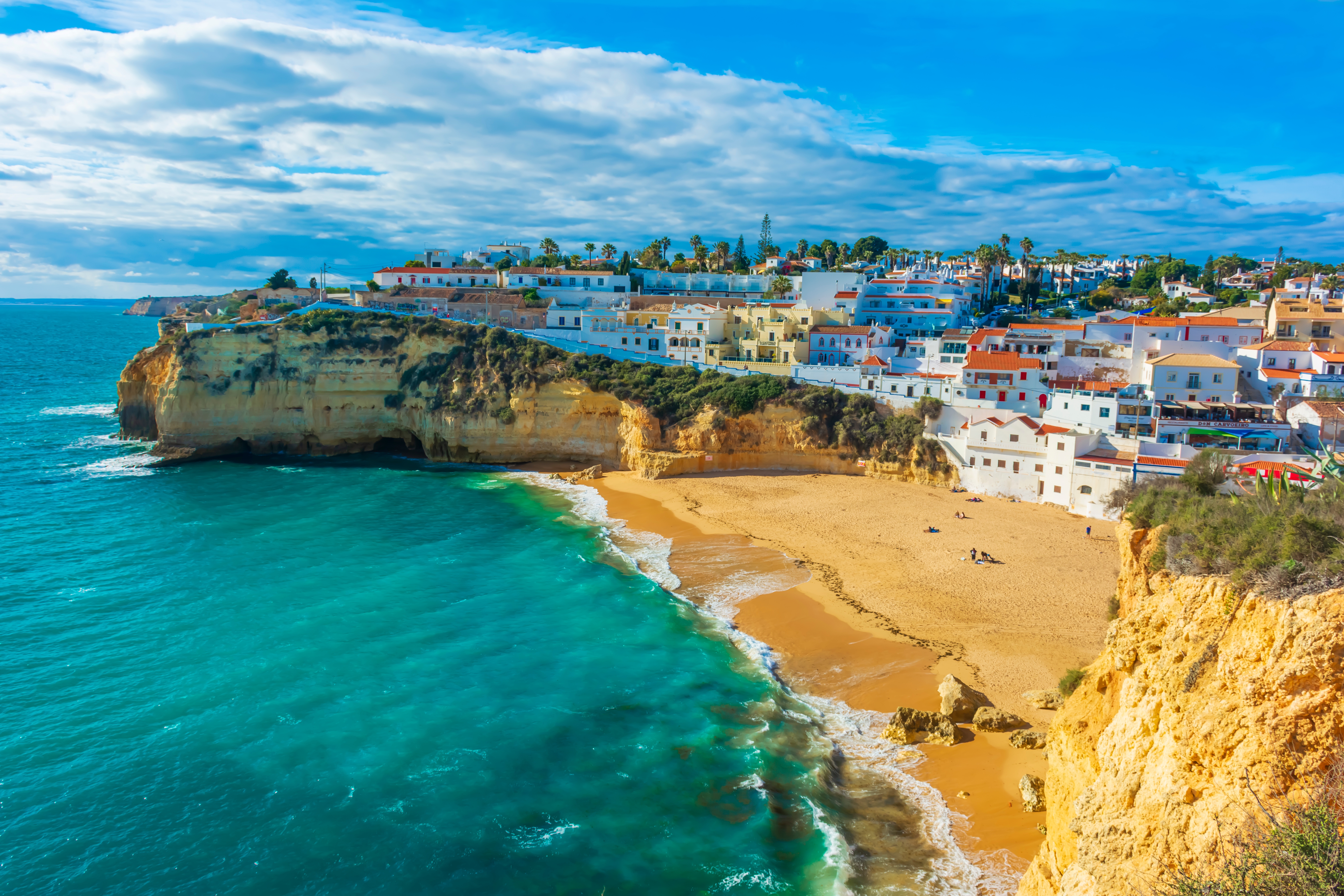 Panoramaudsigt over den charmerende by Carvoeiro i Algarve med smukke klipper, krystalklart vand og traditionelle hvide huse ved kysten