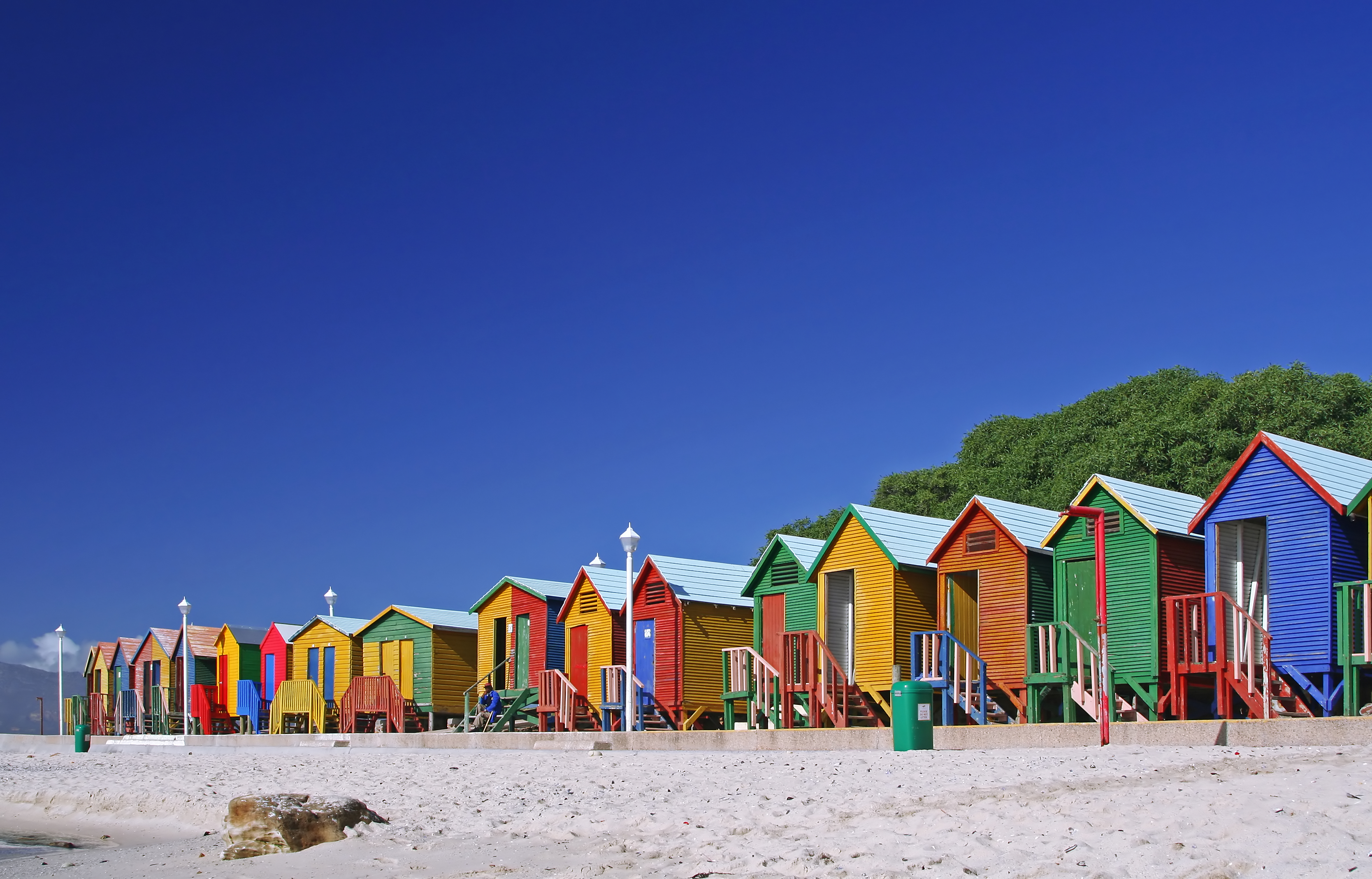 Rækken af farverige badehuse på sandstrand i Kapstad, Sydafrika