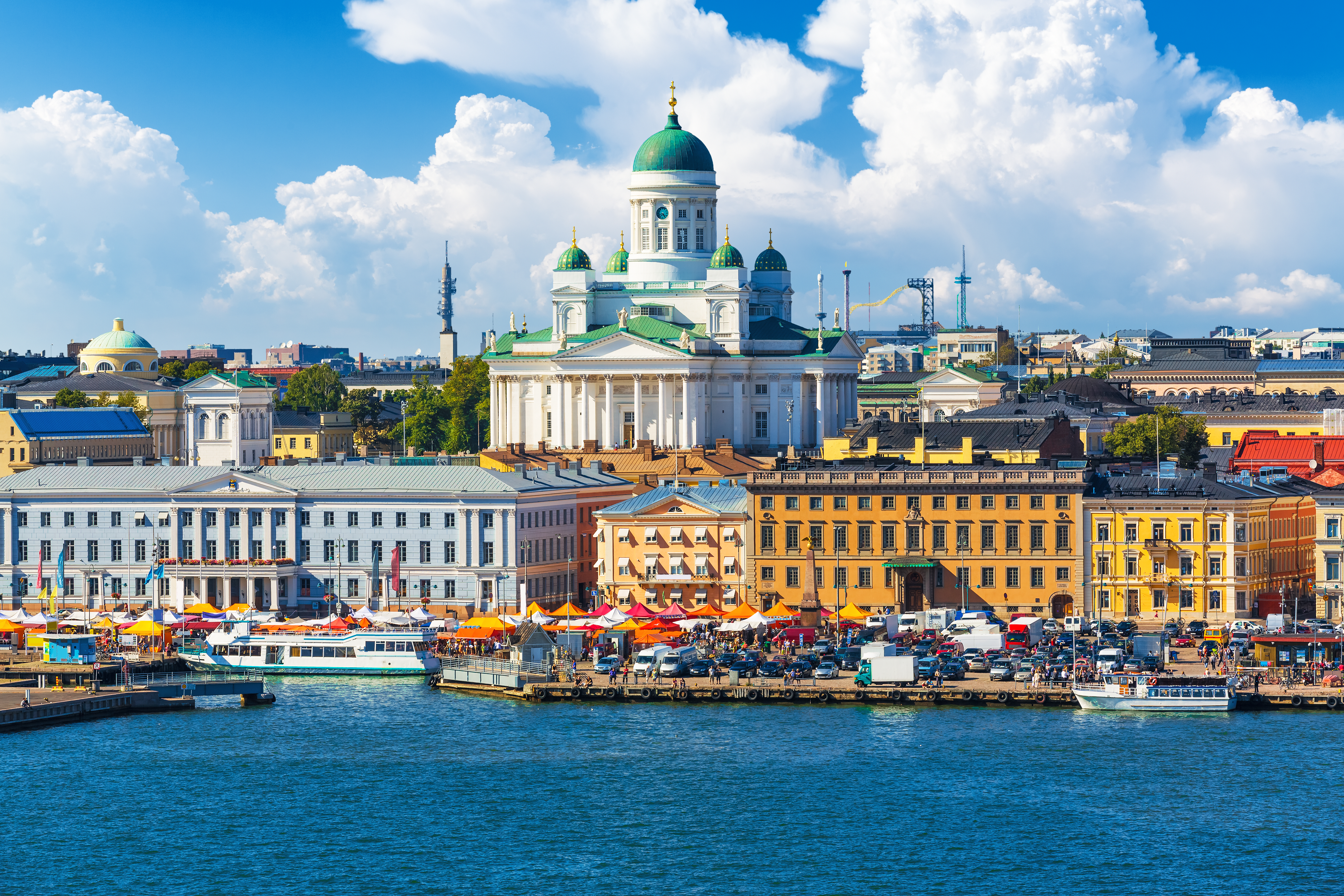 Malerisk sommerudsigt over torvet Kauppatori og den livlige havnefront i Helsinkis centrum med både og historiske bygninger