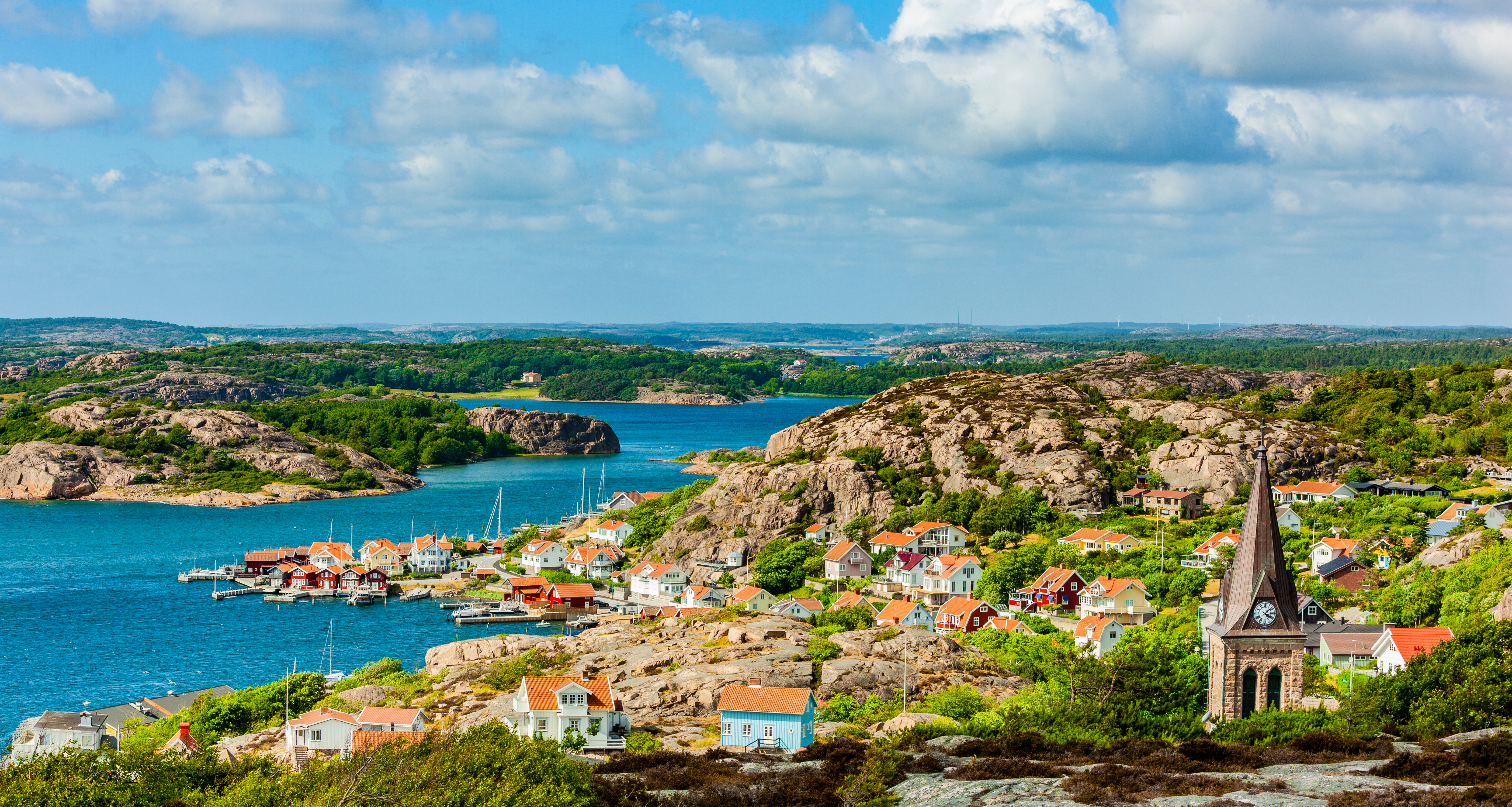 Sommerstemning i Fjällbacka med udsigt over den smukke skærgård, lystbådehavn og hyggelige farverige huse i Sverige