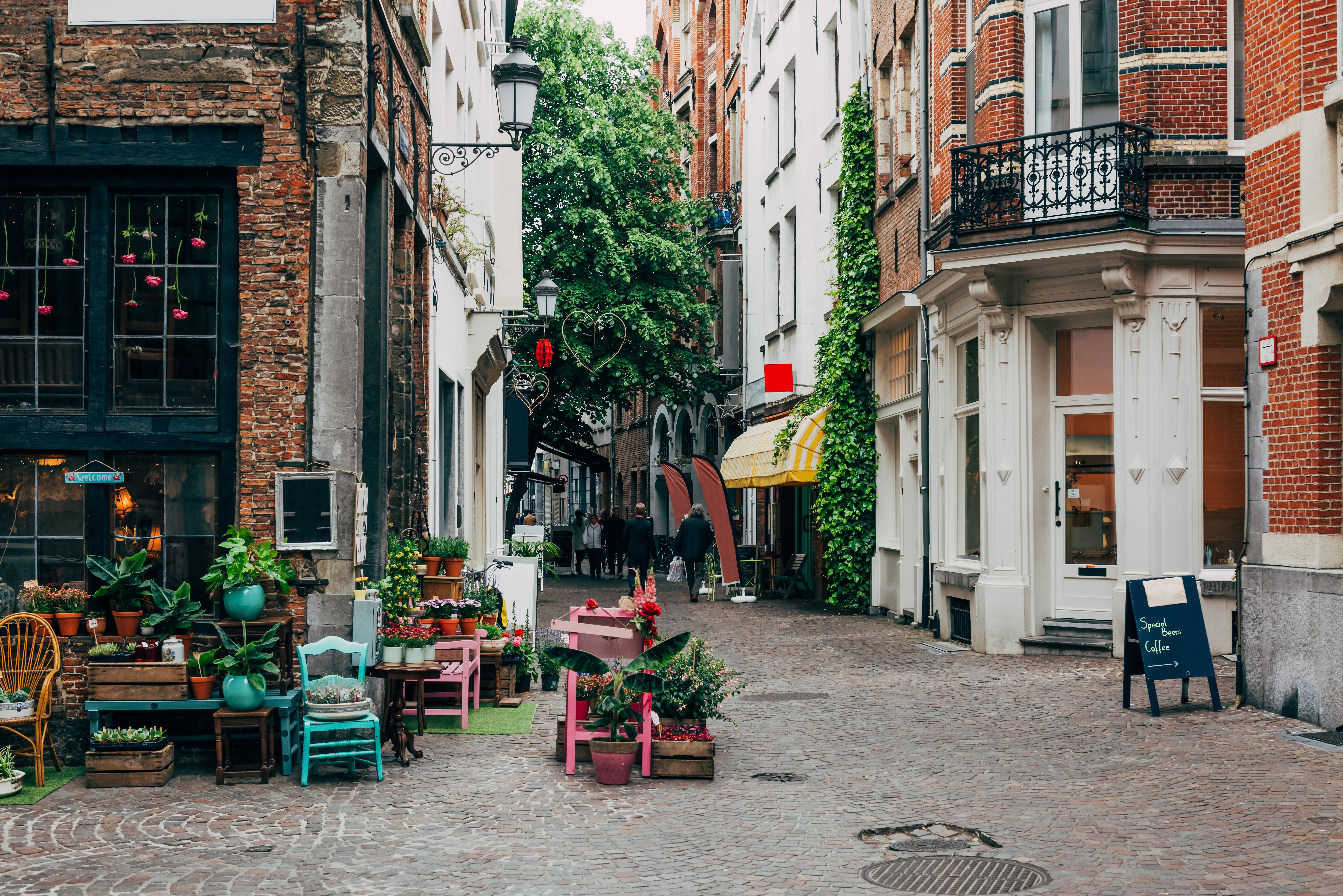 Charmerende smal gade med blomsterbutik i Antwerpens historiske centrum, hvor traditionelle flamske bygninger skaber en hyggelig og autentisk byoplevelse