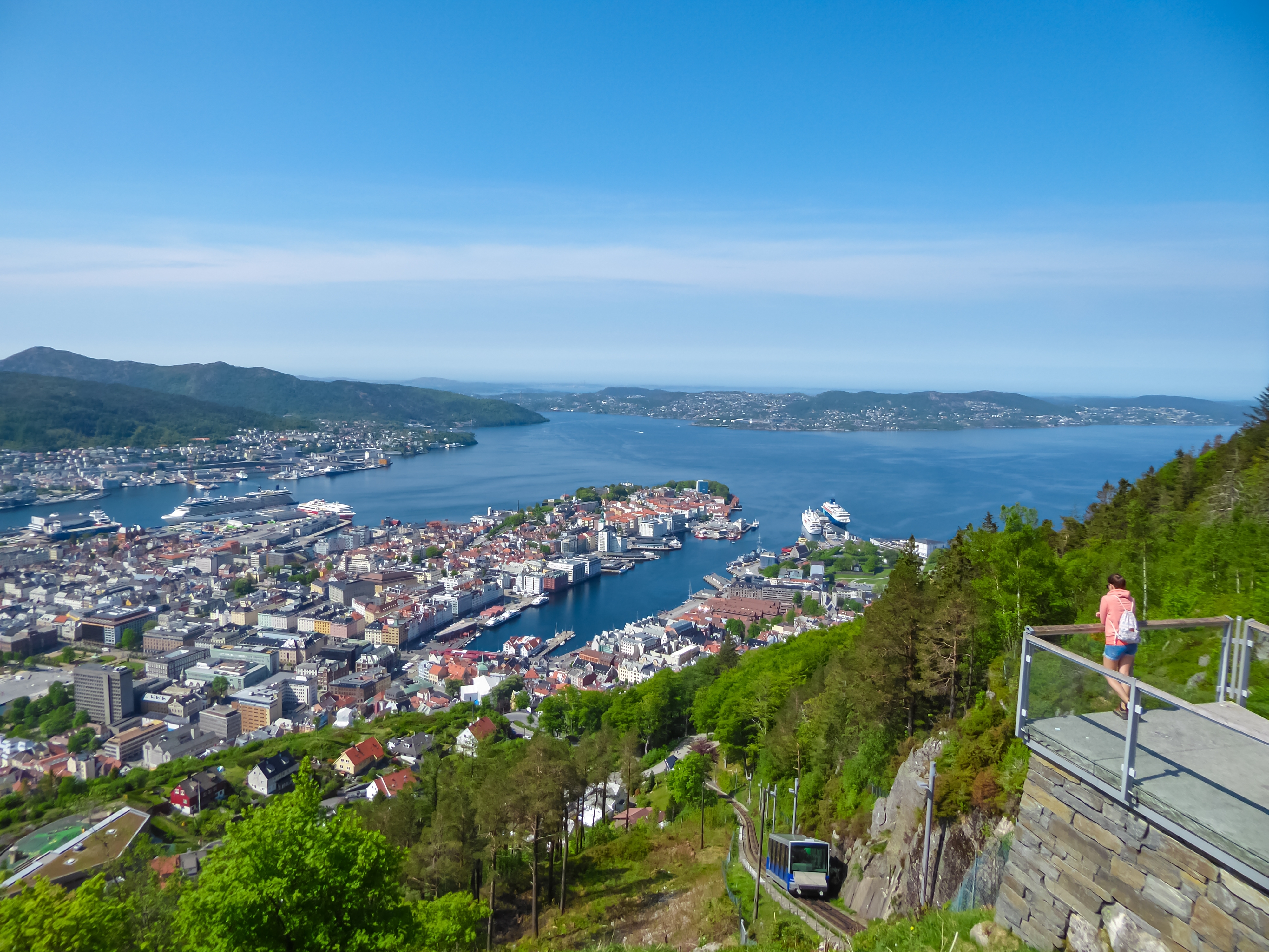 Smuk udsigt fra Mount Fløyen over Bergen, havnen og de norske fjorde på en solrig sommerdag med Fløibanen synlig på bjergsiden