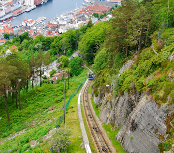 Panoramaudsigt over Bergen fra Fløibanen tandhjulsbane med togbanen der slynger sig ned ad den skovklædte bjergside mod den historiske norske havn