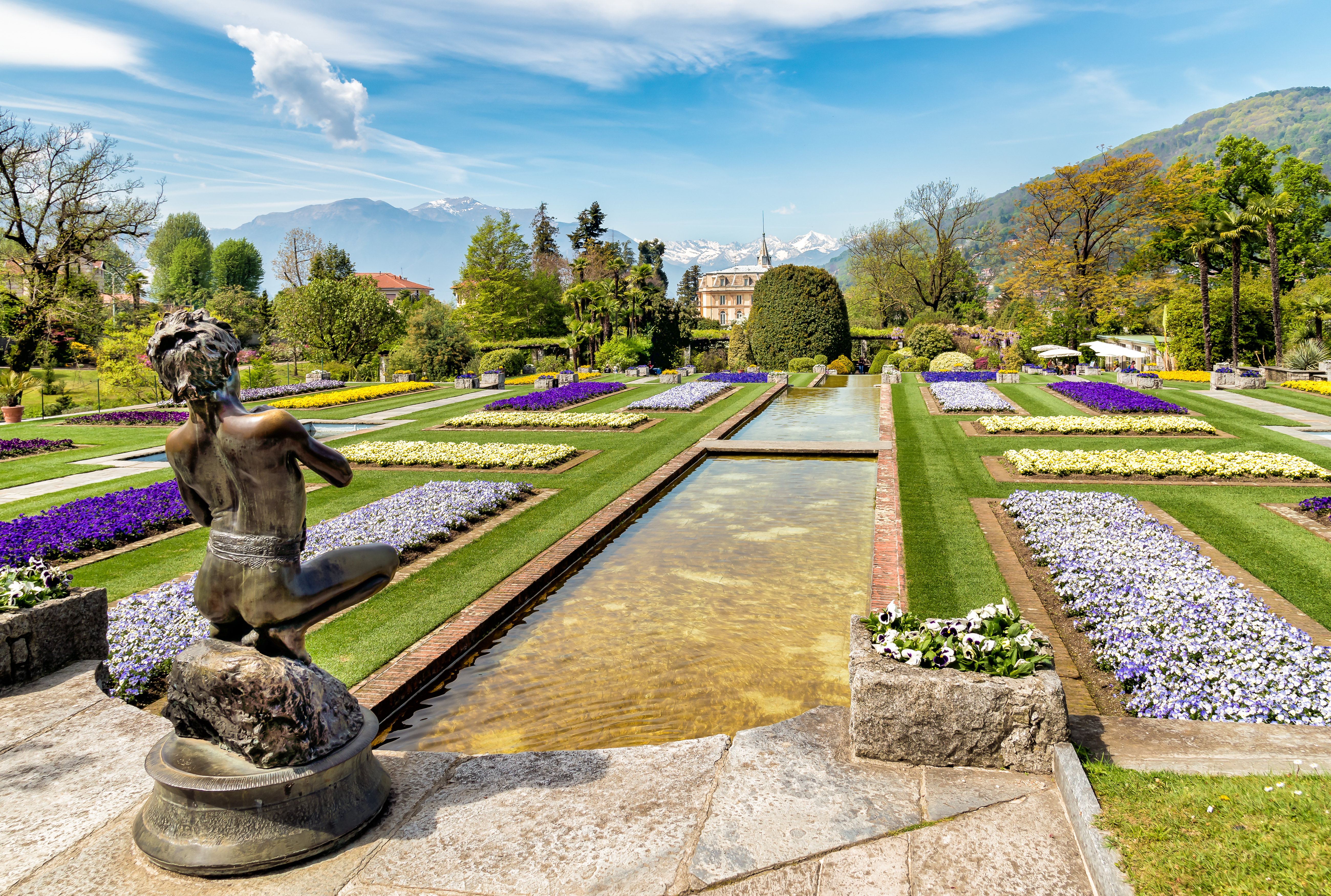 Formelle haver med statue og farverige blomster ved Villa Taranto i Piedmont, Italien