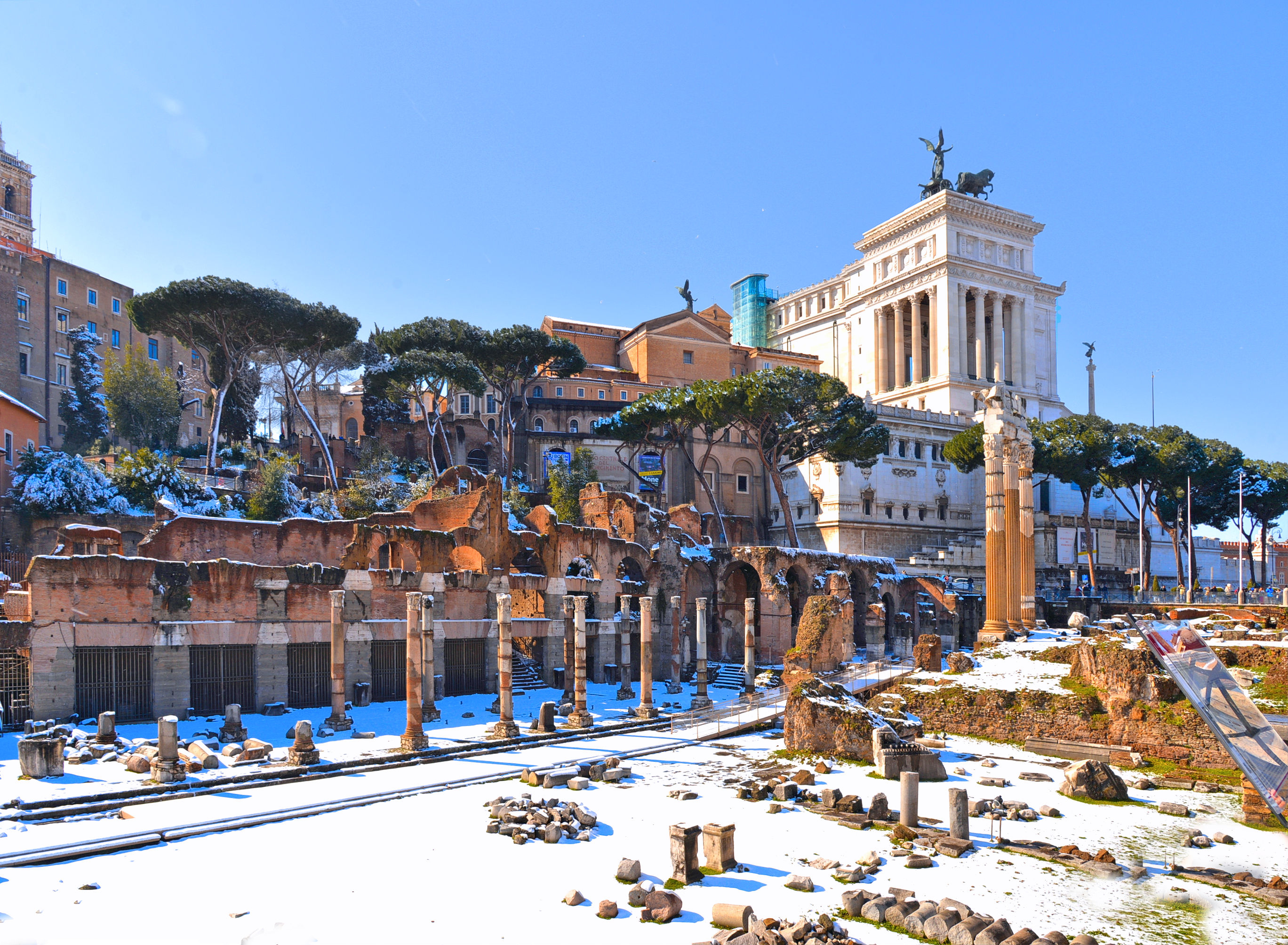 Vinteridyl ved de antikke ruiner på Forum Romanum med Vittoriano-monumentet og sne i Rom, Italien