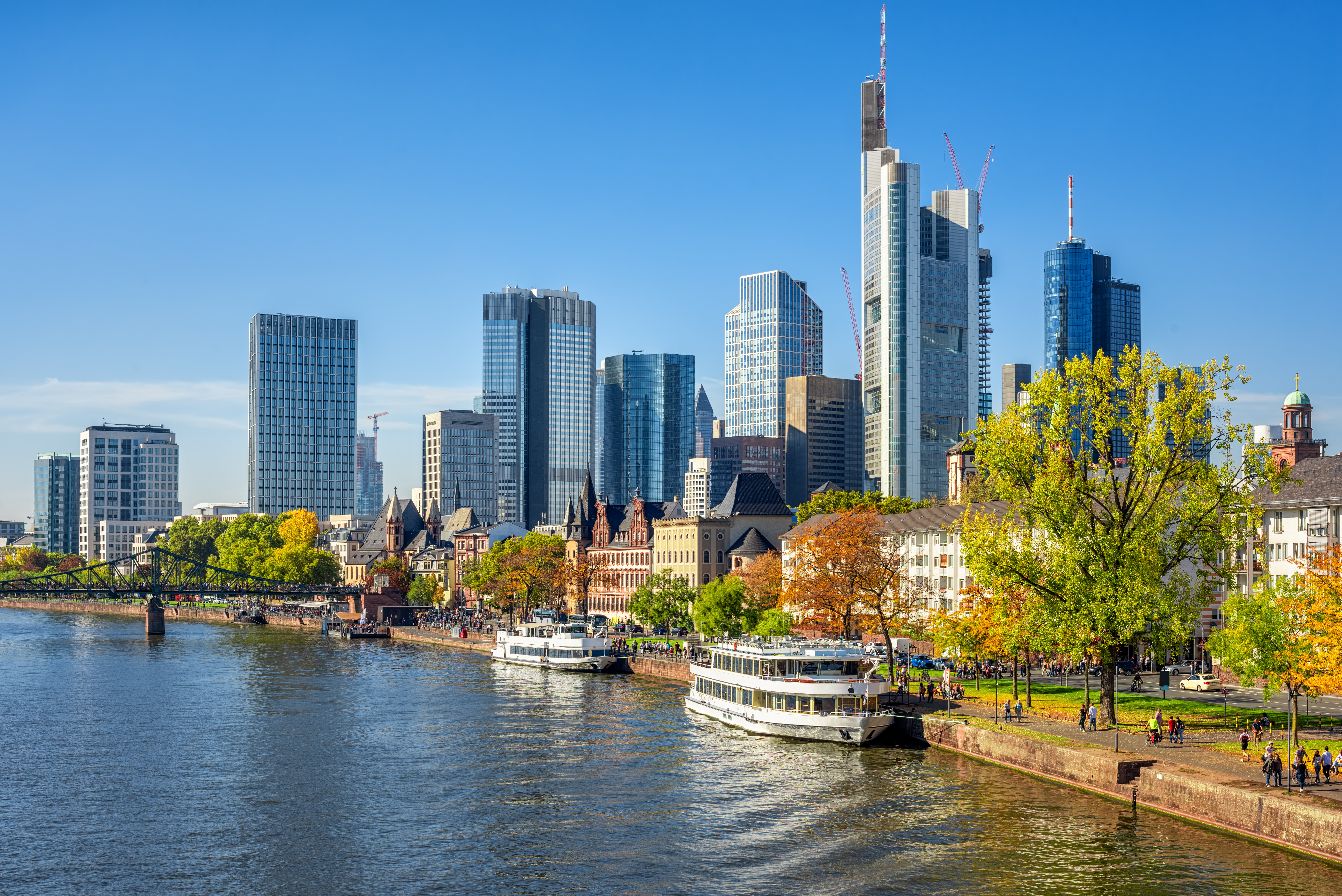 Frankfurt Main-flod med imponerende skyskrabere og krydstogtskibe i efterårslandskab
