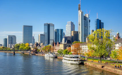 Frankfurt Main-flod med imponerende skyskrabere og krydstogtskibe i efterårslandskab