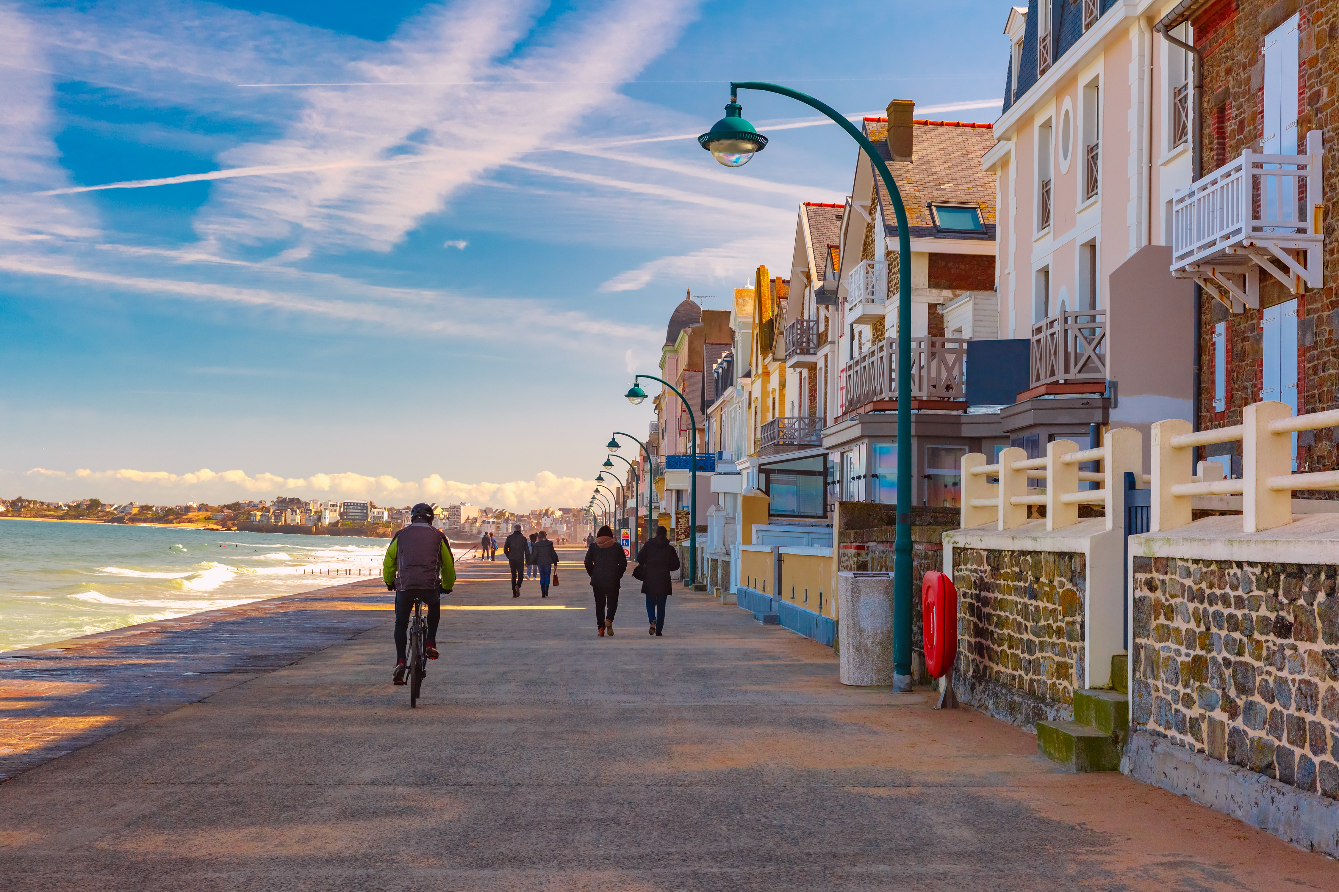 Charmerende kystpromenade i Saint-Malo med traditionelle bretanske huse og aktive turister