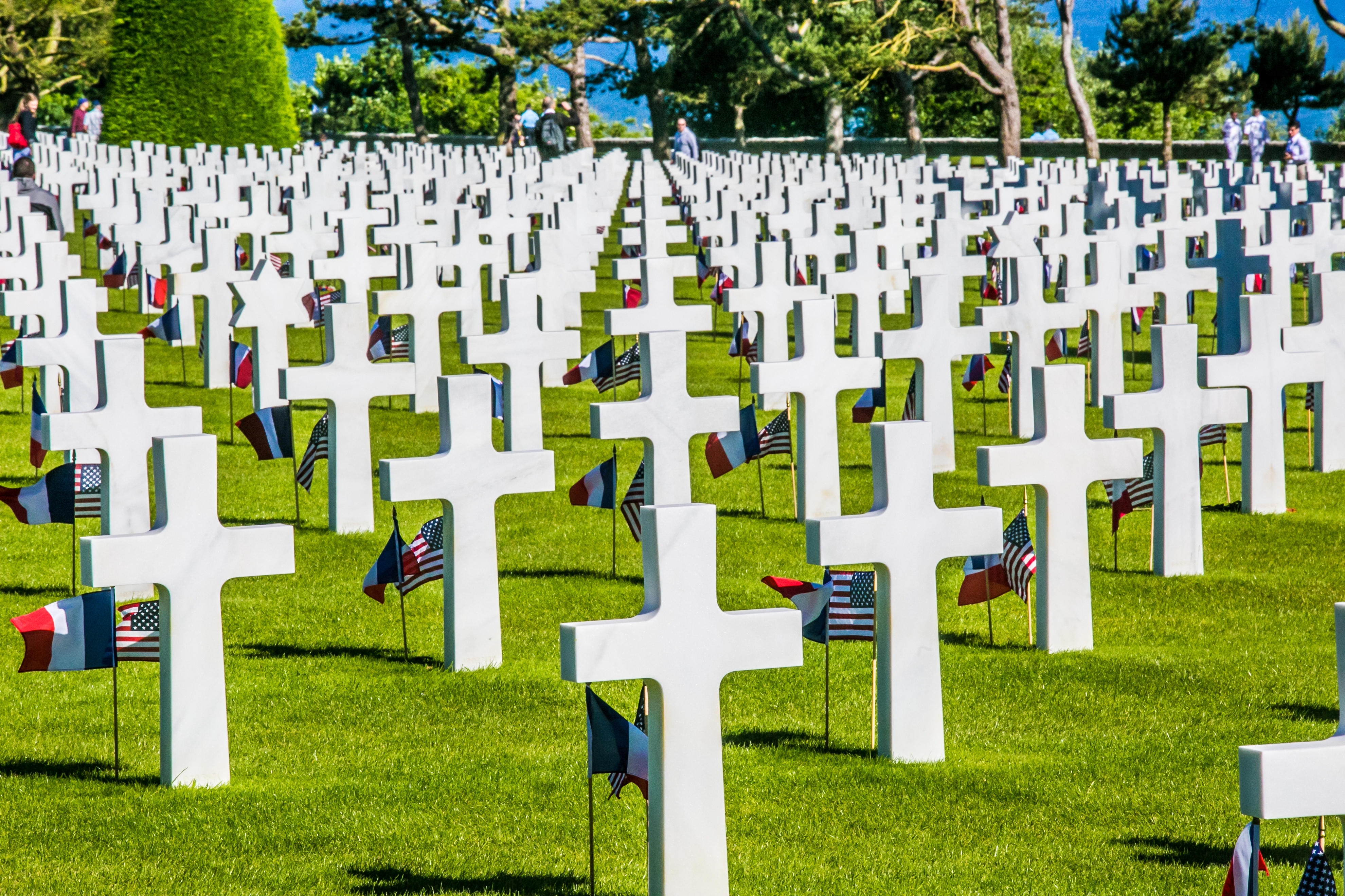 Fransk militær kirkegård i Normandy med rækker af hvide kors og amerikanske flag