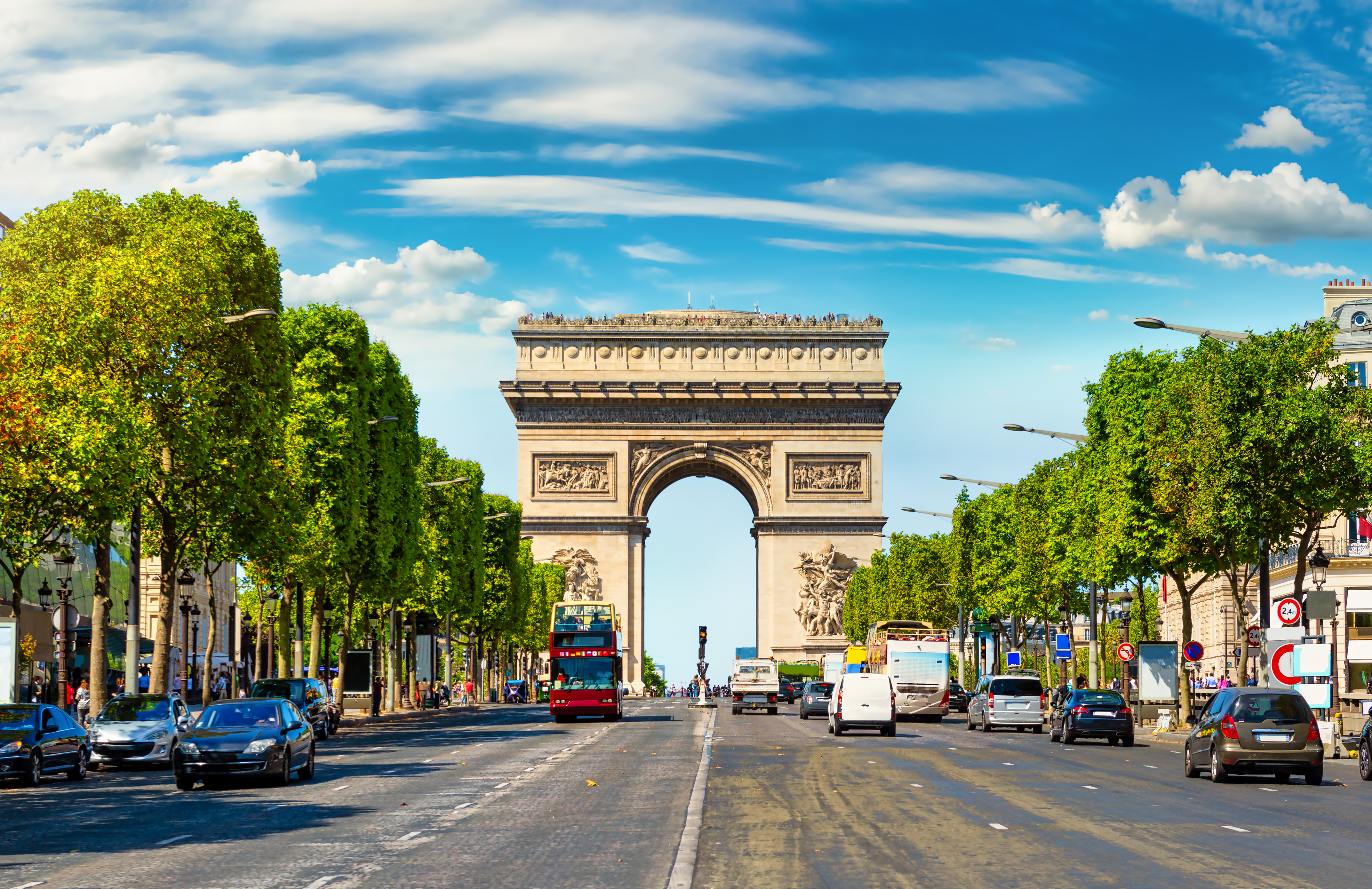 Champs-Élysées i Paris med sin brede boulevard flankeret af træer, der fører til den monumentale Triumfbue - kendt for eksklusive butikker og det pulserende byliv