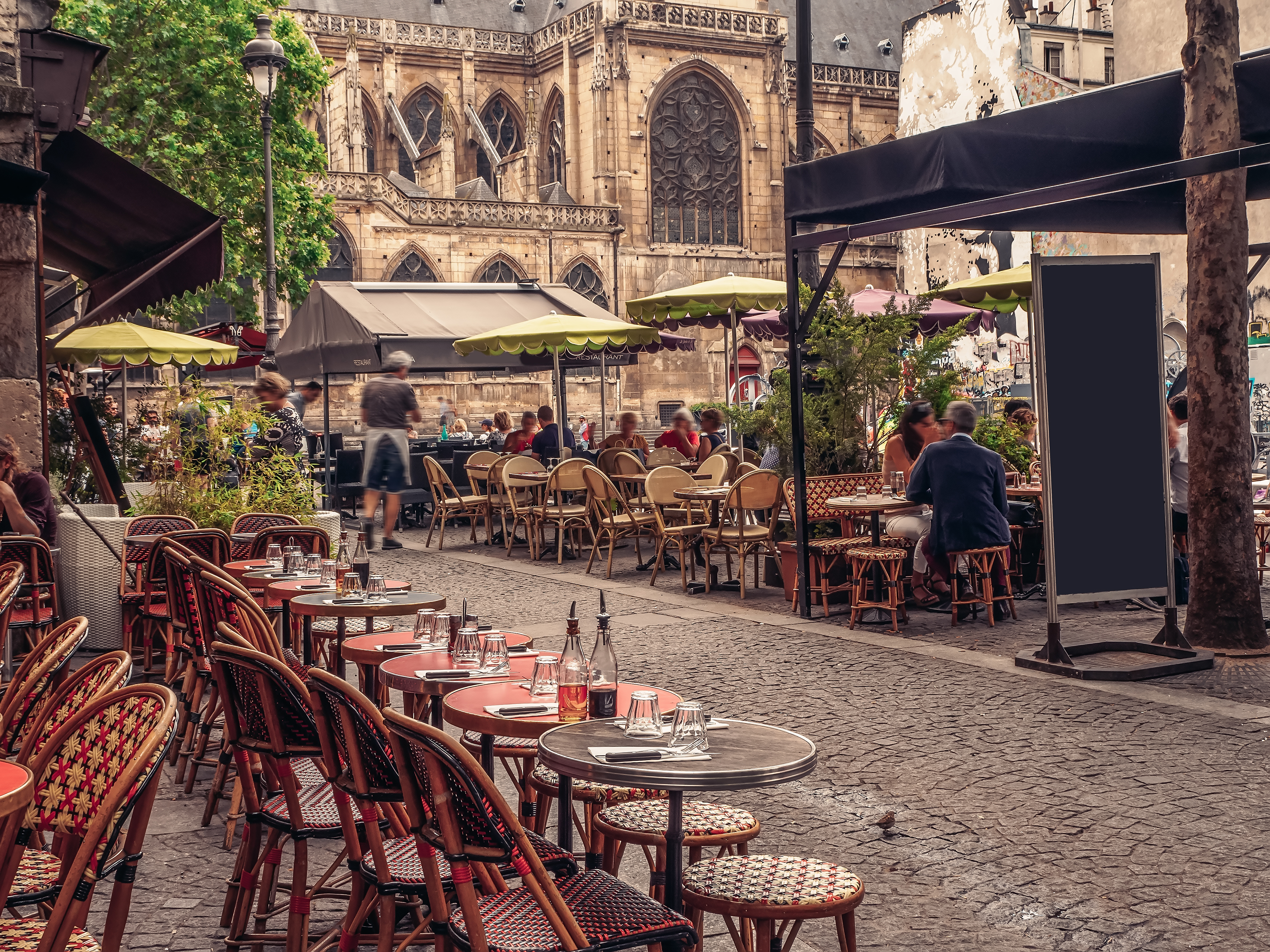 Hyggelig fransk restaurant terrasse med middelalderlig arkitektur i baggrunden