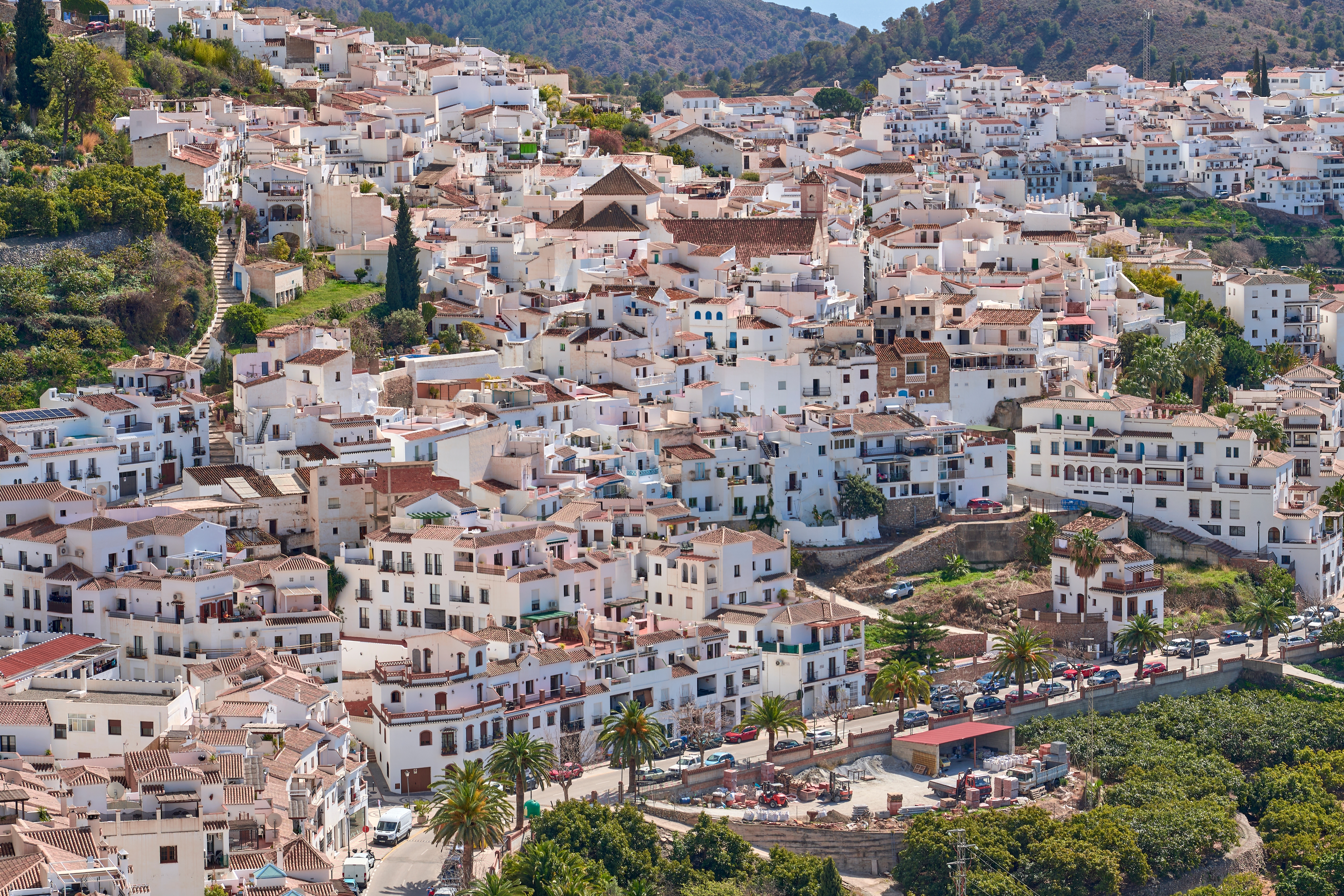 Smuk luftudsigt over Frigiliana i Spanien med karakteristiske hvidkalkede huse der kravler op ad bjergskrænterne i Andalusien