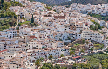 Smuk luftudsigt over Frigiliana i Spanien med karakteristiske hvidkalkede huse der kravler op ad bjergskrænterne i Andalusien